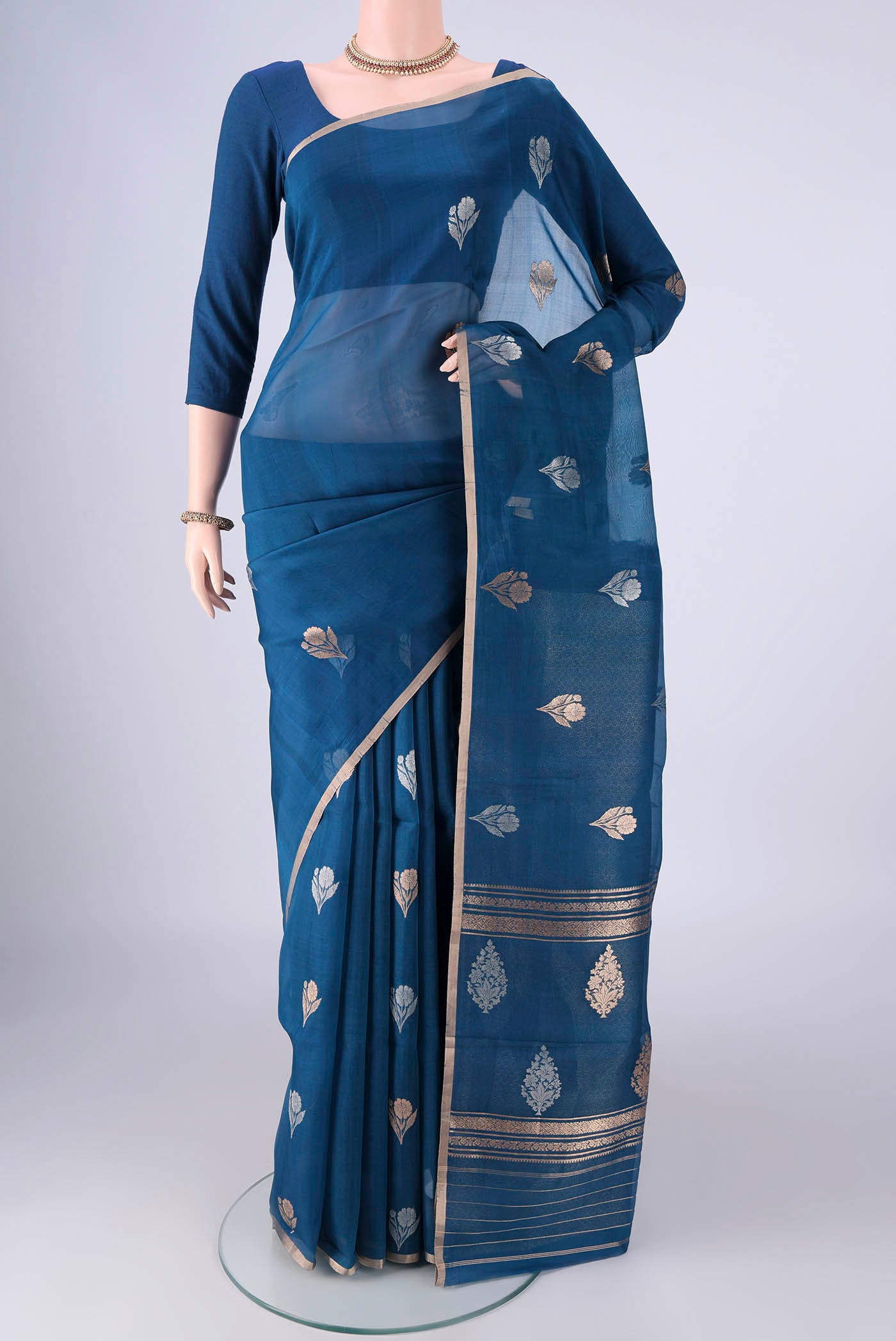 Blue Organza Silk Saree with Zari And Thread Butta on the body and Thin Zari Line.  displayed on a mannequin
