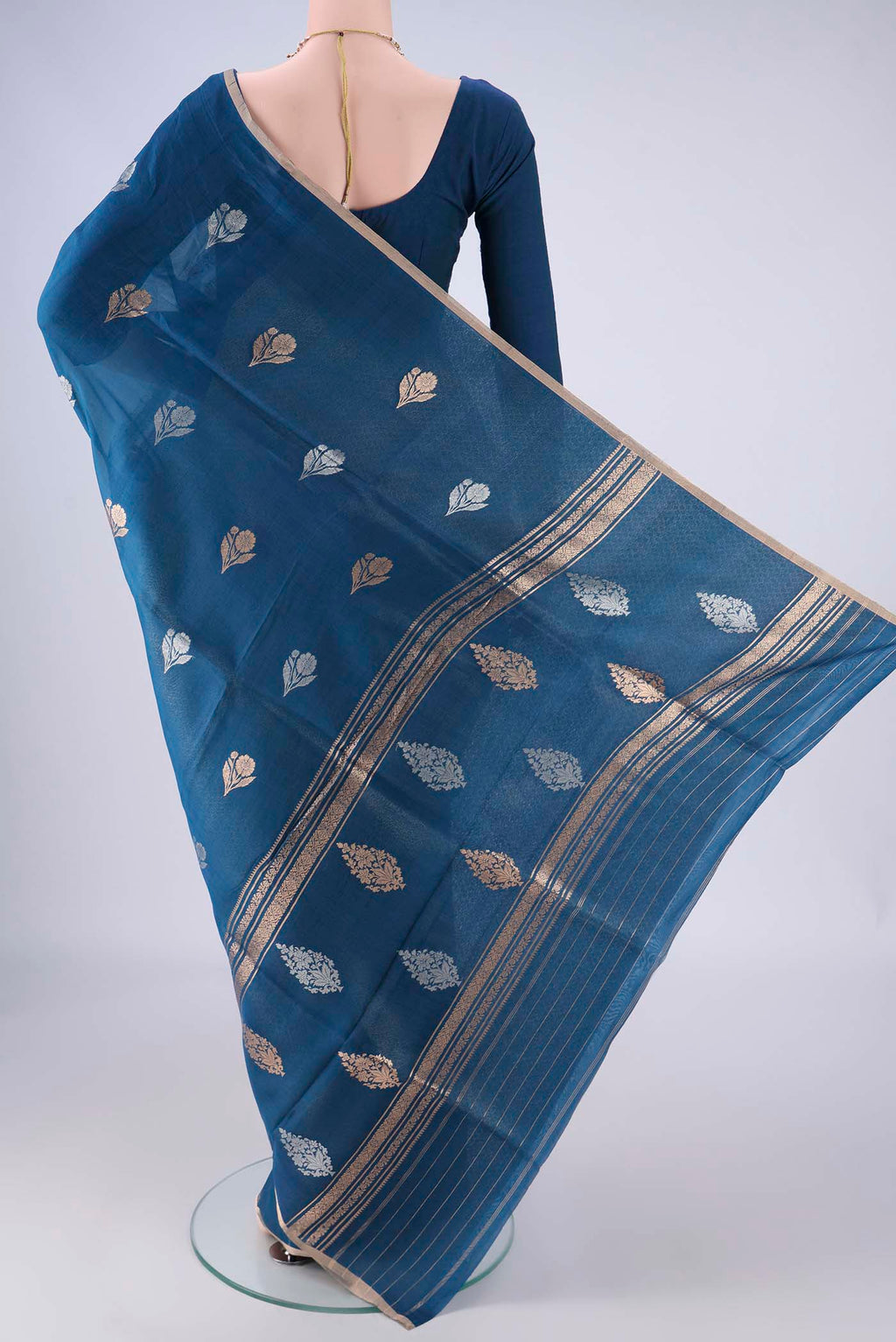 Flat view of Blue Organza Silk Saree with Zari And Thread Butta on the body and Thin Zari Line. 
