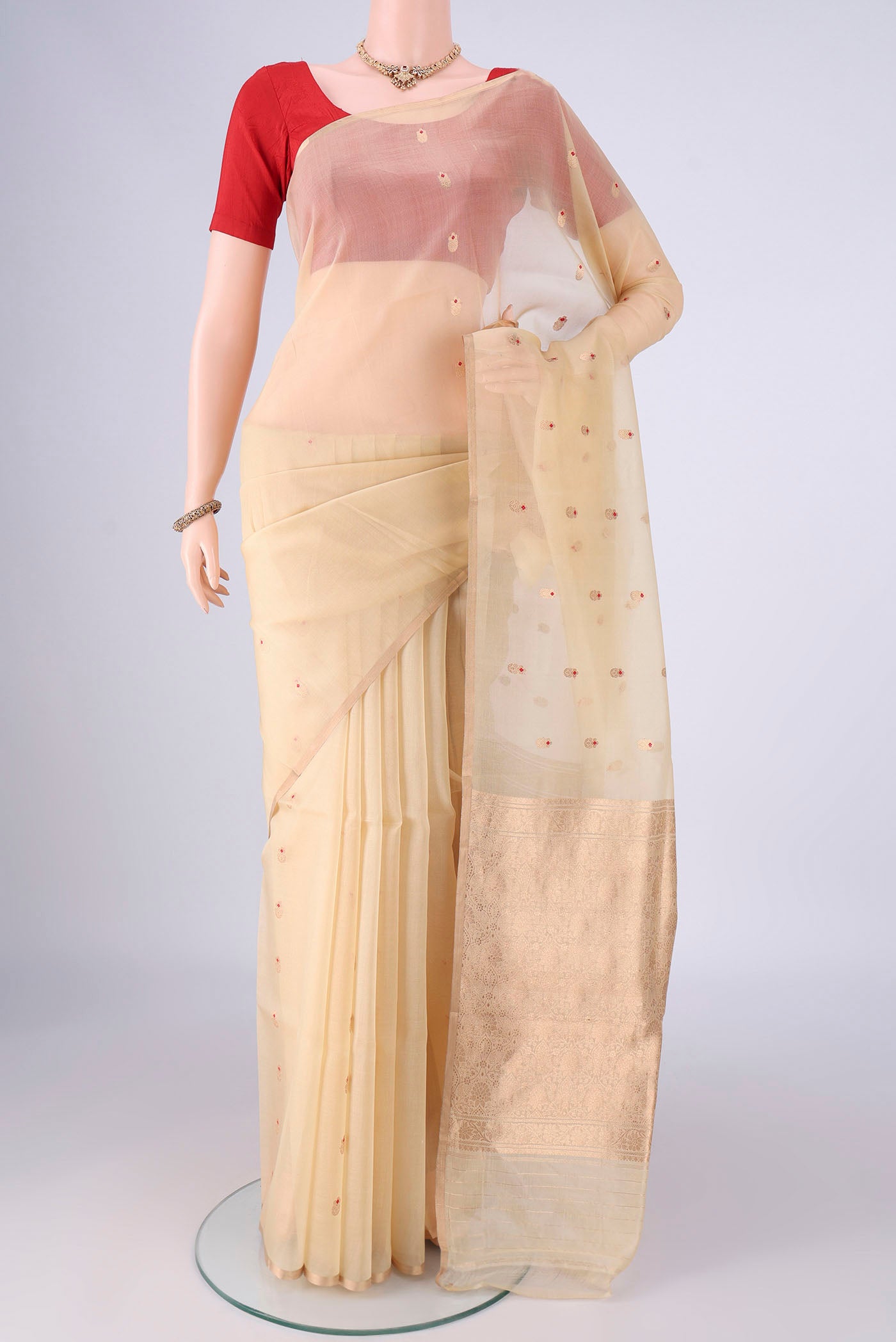 Cream Organza Silk Saree with Zari And Thread Butta on the body and Thin Zari Line.  displayed on a mannequin