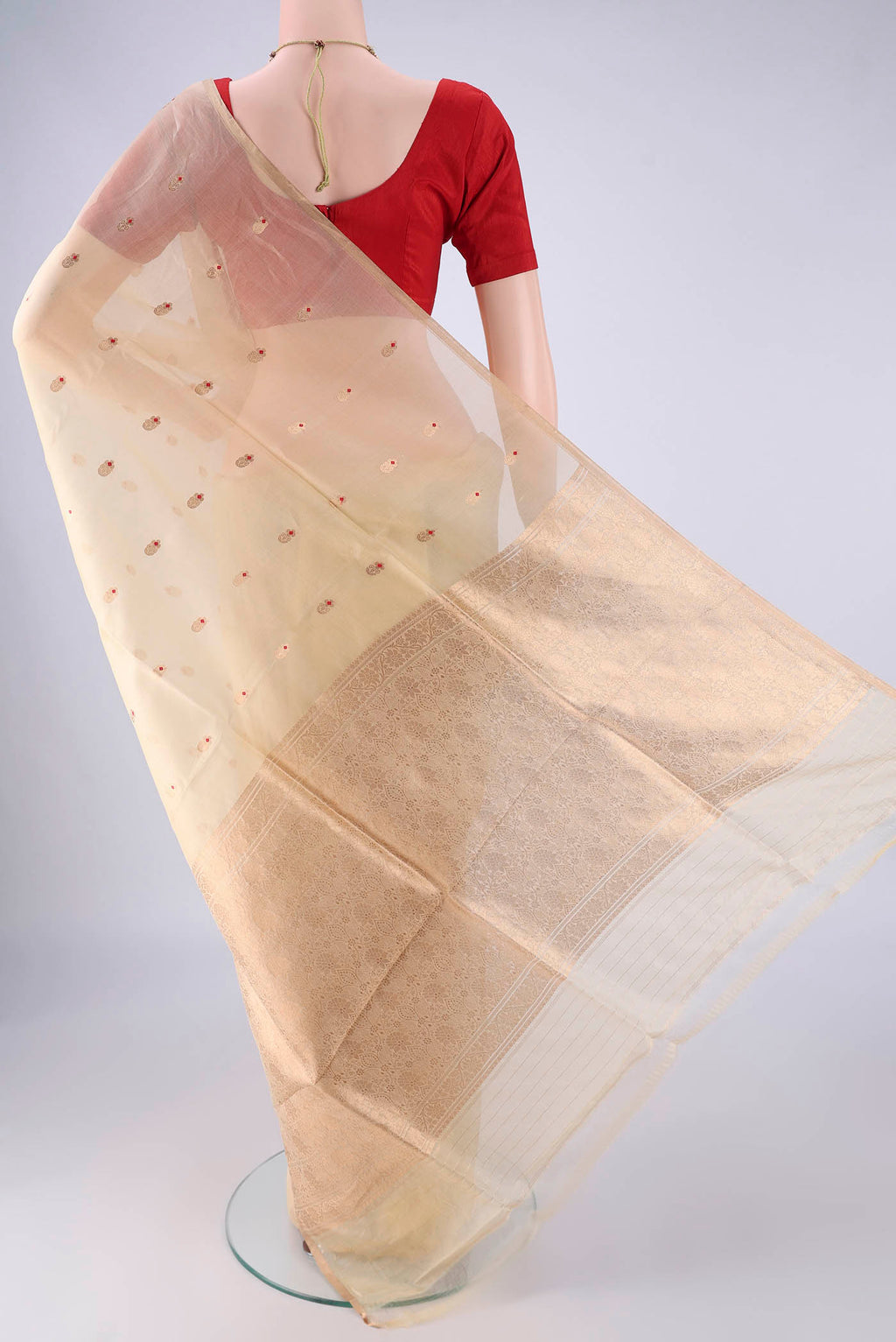Flat view of Cream Organza Silk Saree with Zari And Thread Butta on the body and Thin Zari Line. 