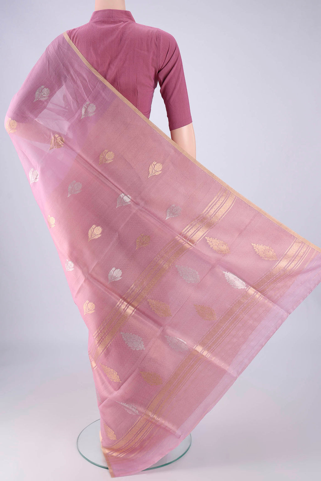 Flat view of Lavender Organza Silk Saree with Zari Butta on the body and Thin Zari Line. 