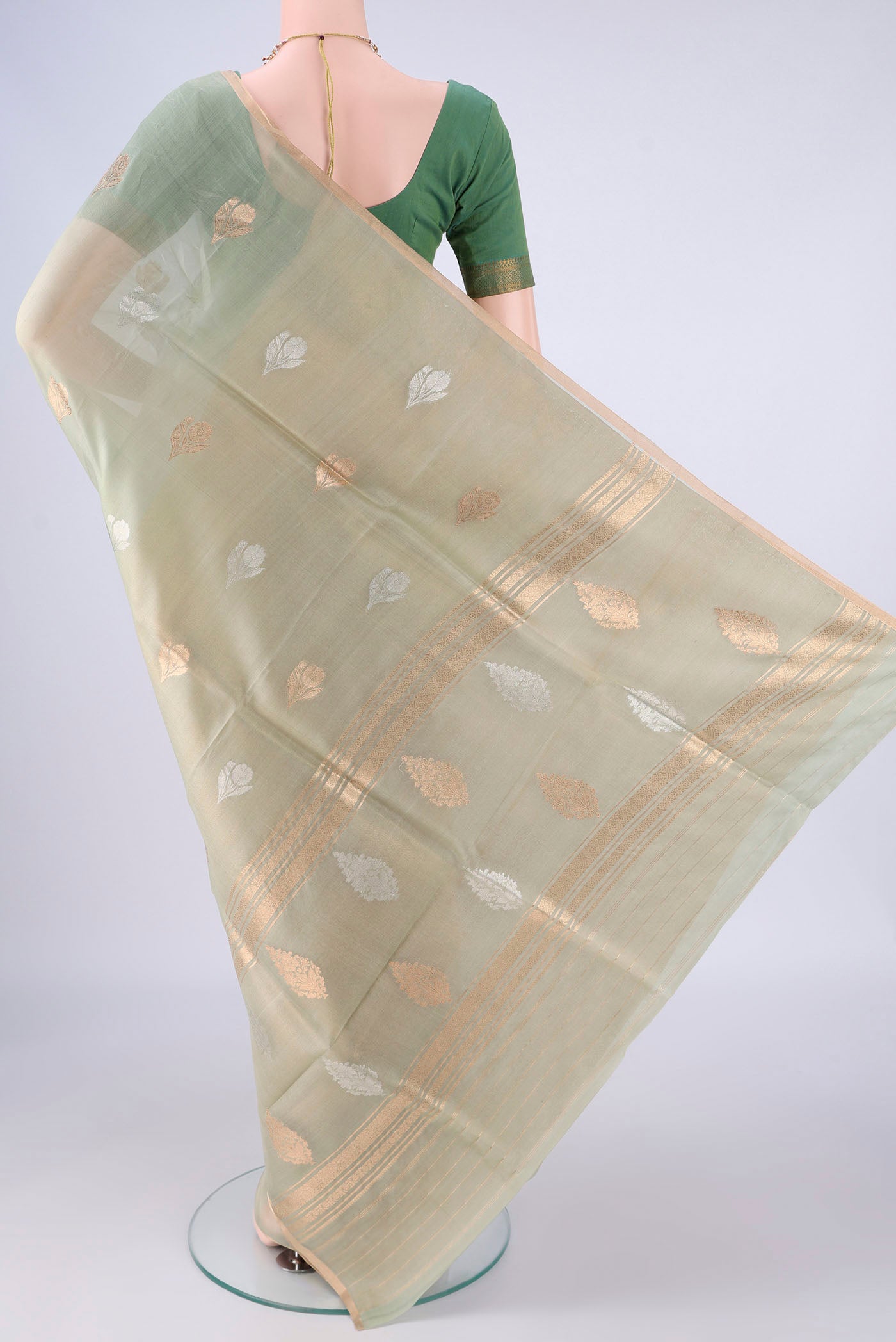 Flat view of Pista Green Organza Silk Saree with Zari Butta on the body and Thin Zari Line. 