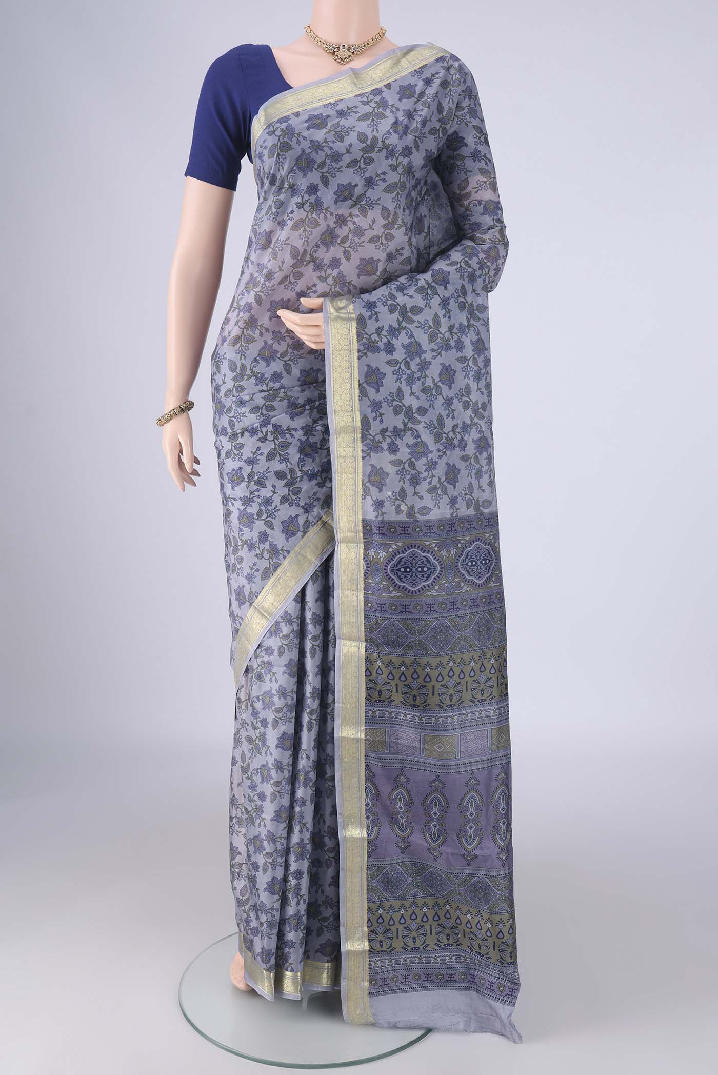 Grey Printed Silk Saree with Printed design on the body and Zari Border.  displayed on a mannequin