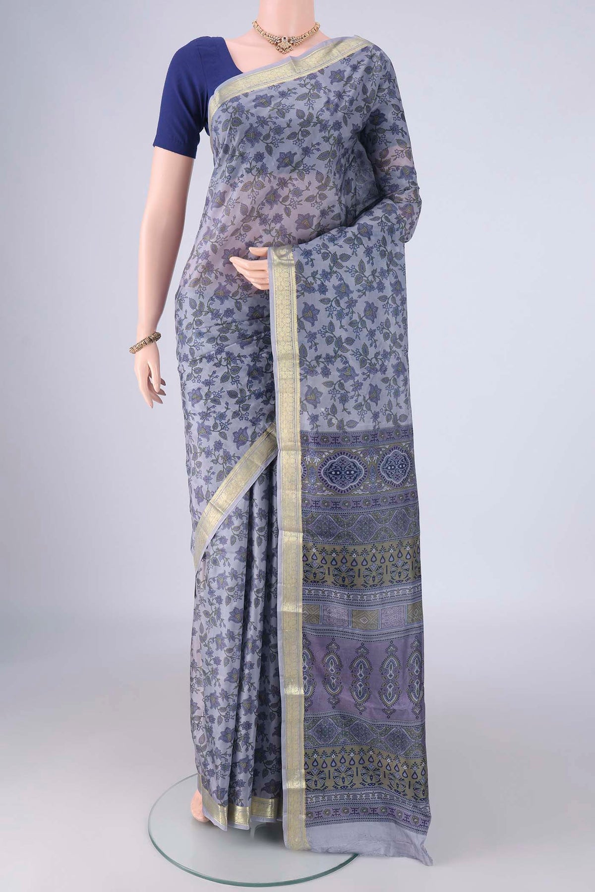 Grey Printed Silk Saree with Printed design on the body and Zari Border.  displayed on a mannequin