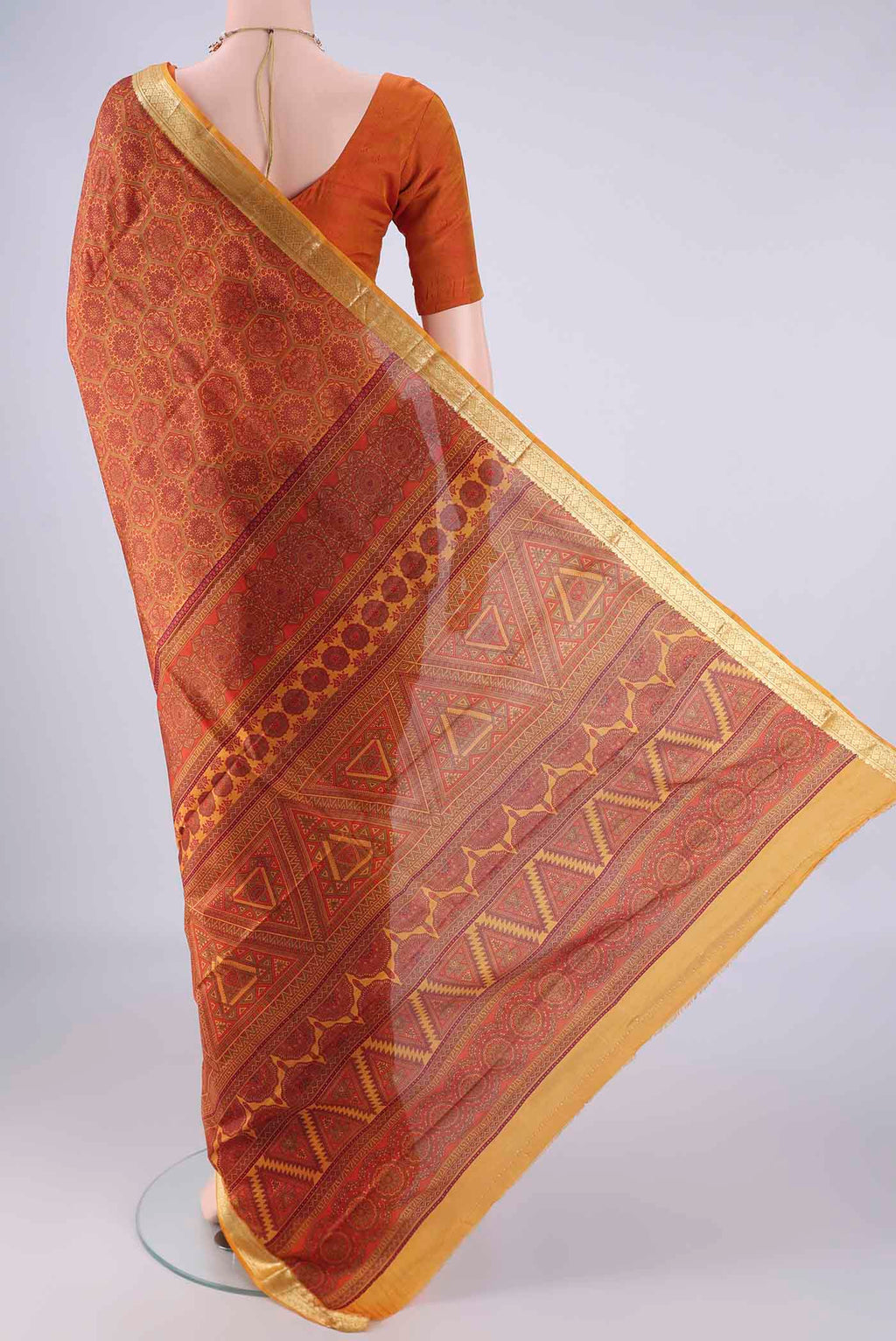Flat view of Rust Printed Silk Saree with Printed design on the body and Zari Border. 