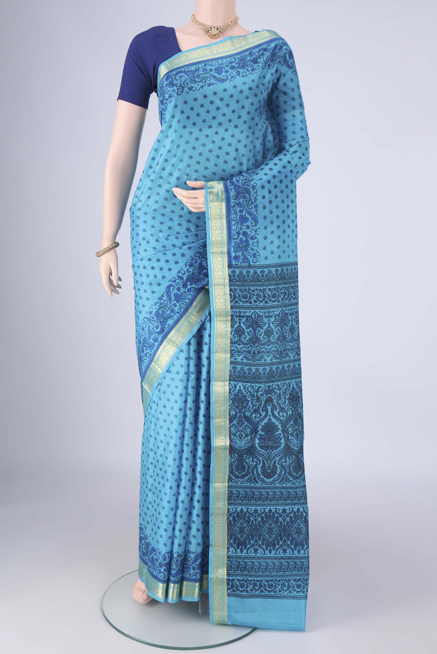 Blue Printed Silk Saree with Printed design on the body and Zari Border.  displayed on a mannequin