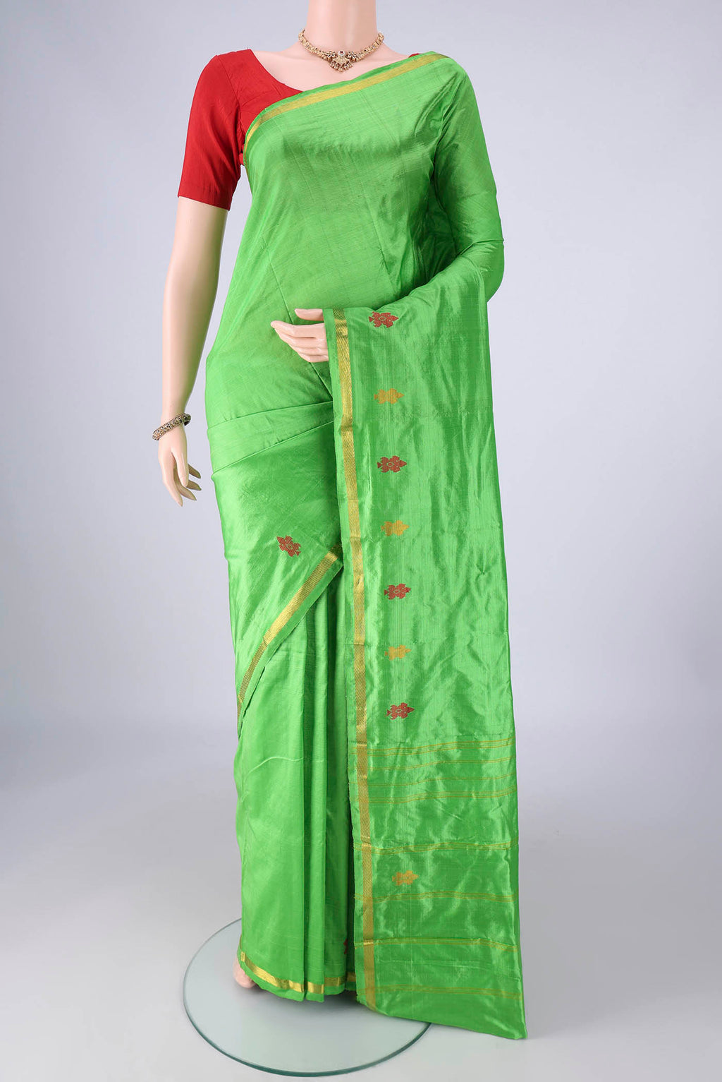Parrot Green Kanchipuram Silk Saree with Plain Body and Zari And Thread Border.  displayed on a mannequin
