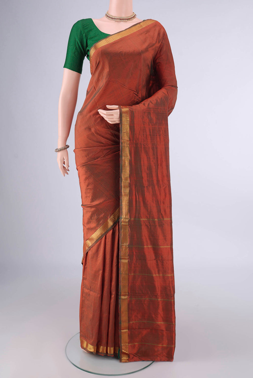 Pure Silk Rust Dual Tone Kanchipuram Saree with Plain Body and Zari Border.  displayed on a mannequin