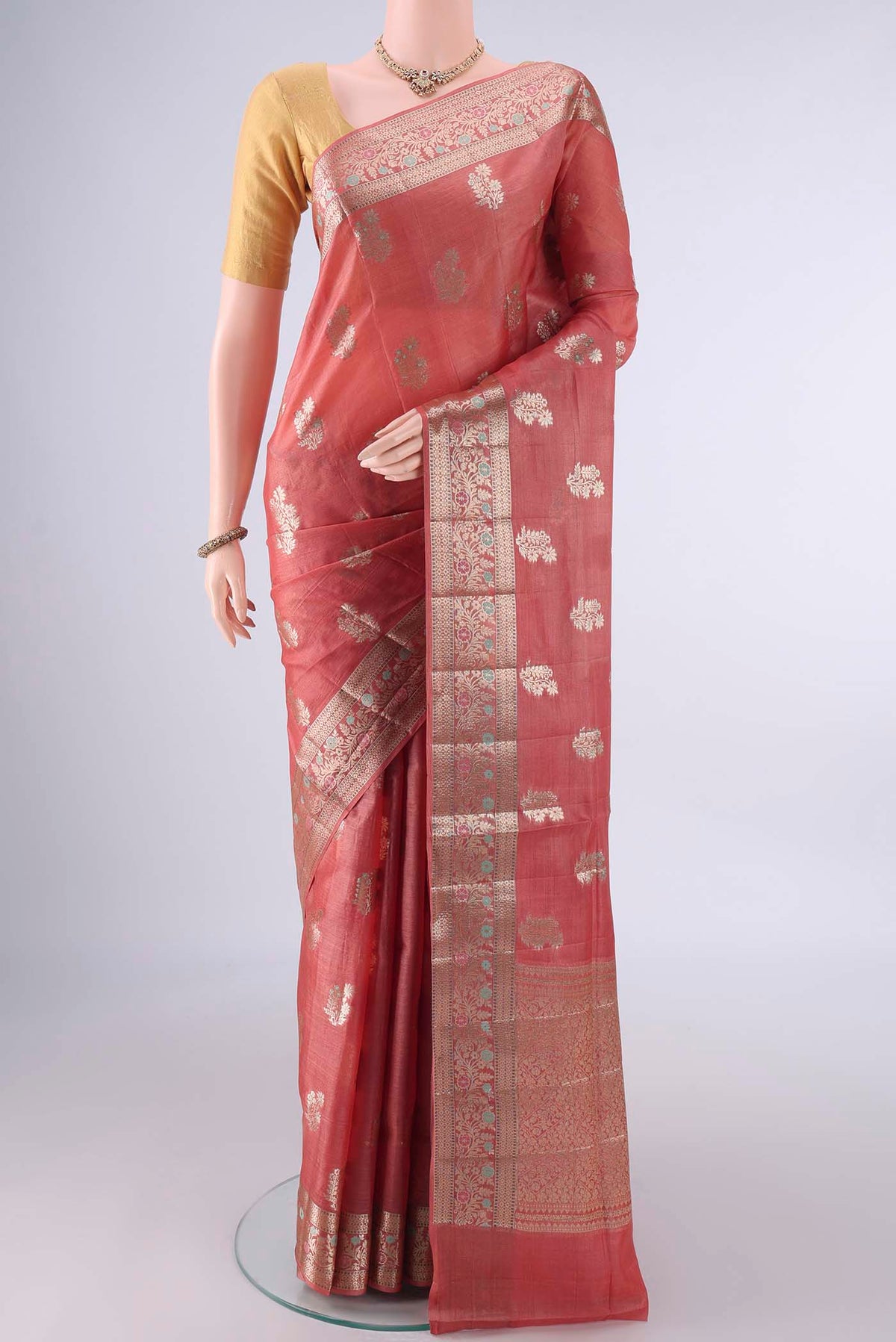 Rust Banarasi Tussar Saree with Zari And Thread Butta on the body and Zari And Thread Border.  displayed on a mannequin