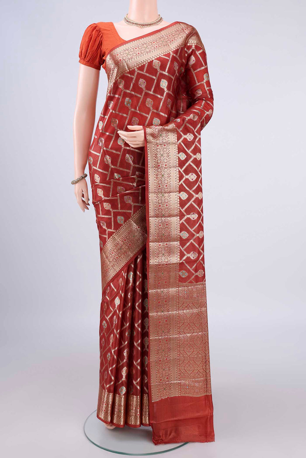 Rust Banarasi Tussar Saree with Zari And Thread Butta on the body and Zari Border.  displayed on a mannequin
