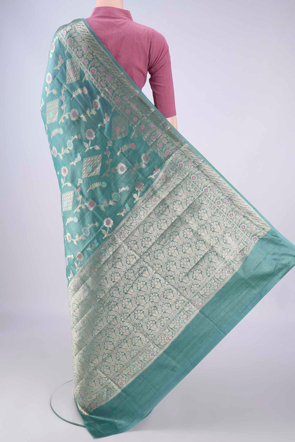 Flat view of Light Blue Banarasi Tussar Silk Saree with Zari And Thread Butta on the body and Zari Border. 