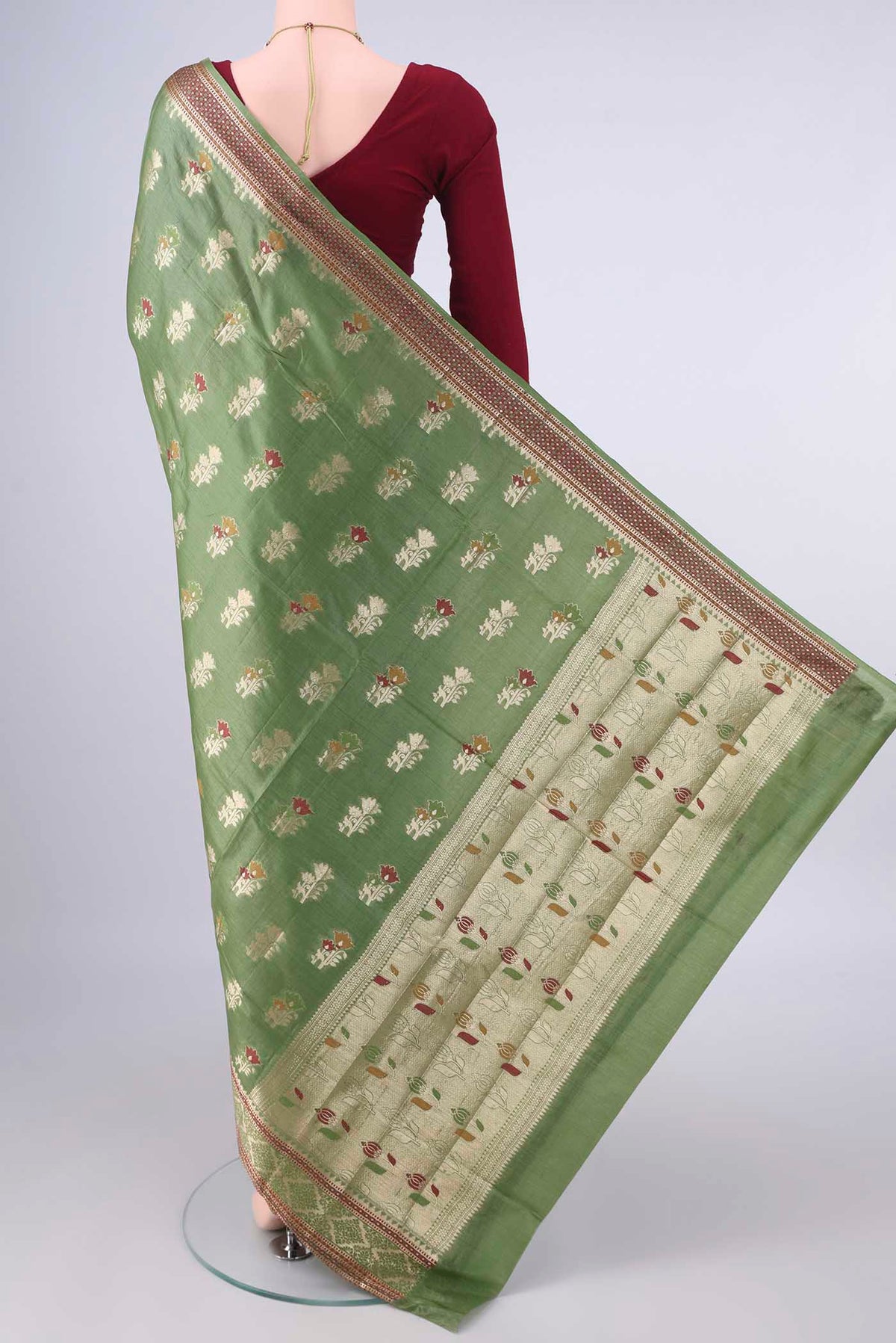Flat view of Olive Green Banarasi Tussar Saree with Zari And Thread Butta on the body and Zari And Thread Border. 