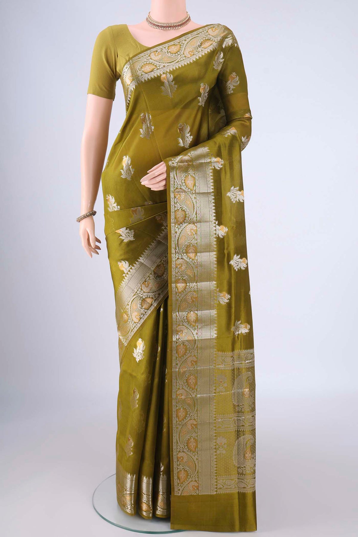 Mehandi Green Banarasi Raw Silk Saree with Zari Butta on the body and Zari Border.  displayed on a mannequin