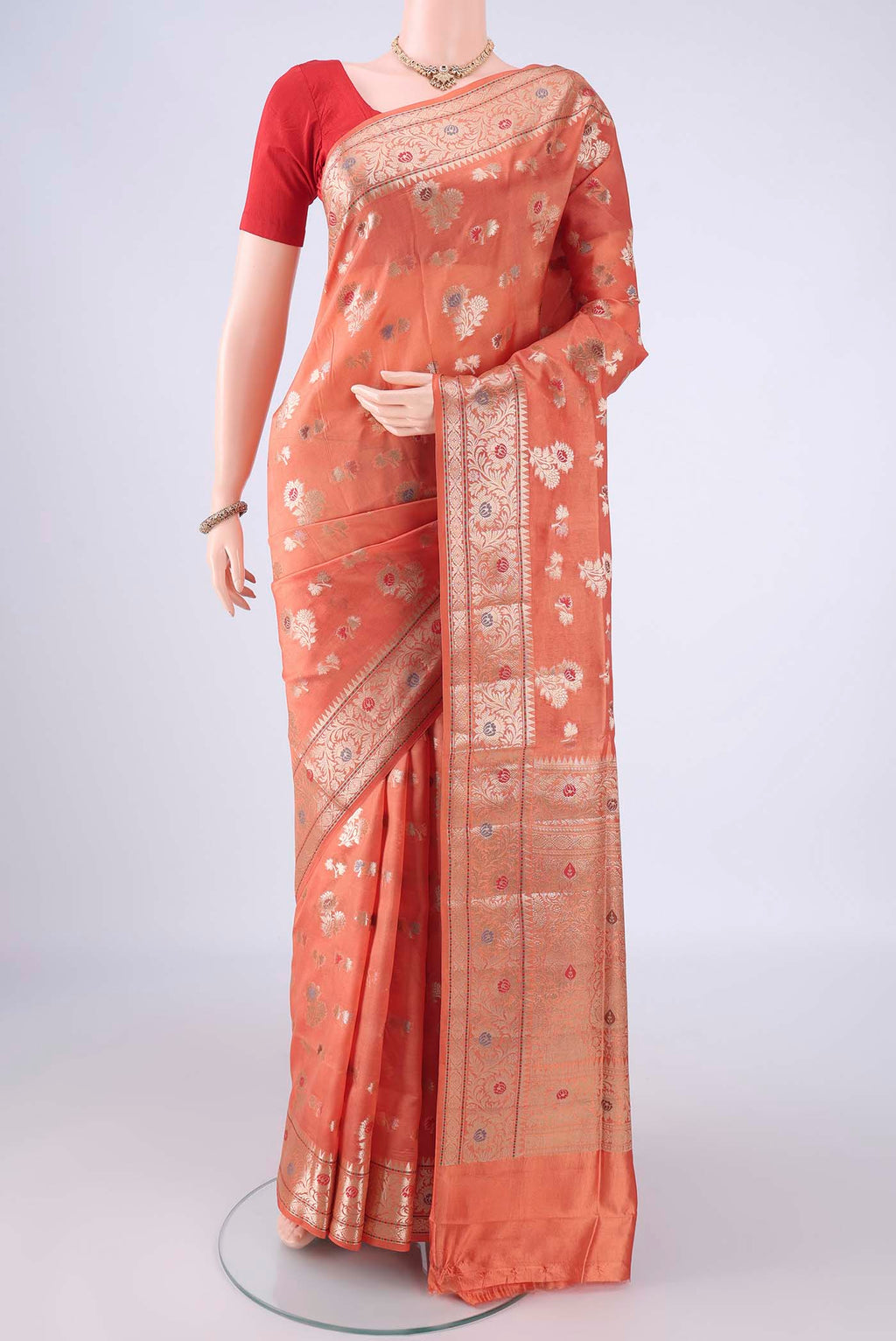 Peach Banarasi Raw Silk Saree with Zari And Thread Butta on the body and Zari Border.  displayed on a mannequin
