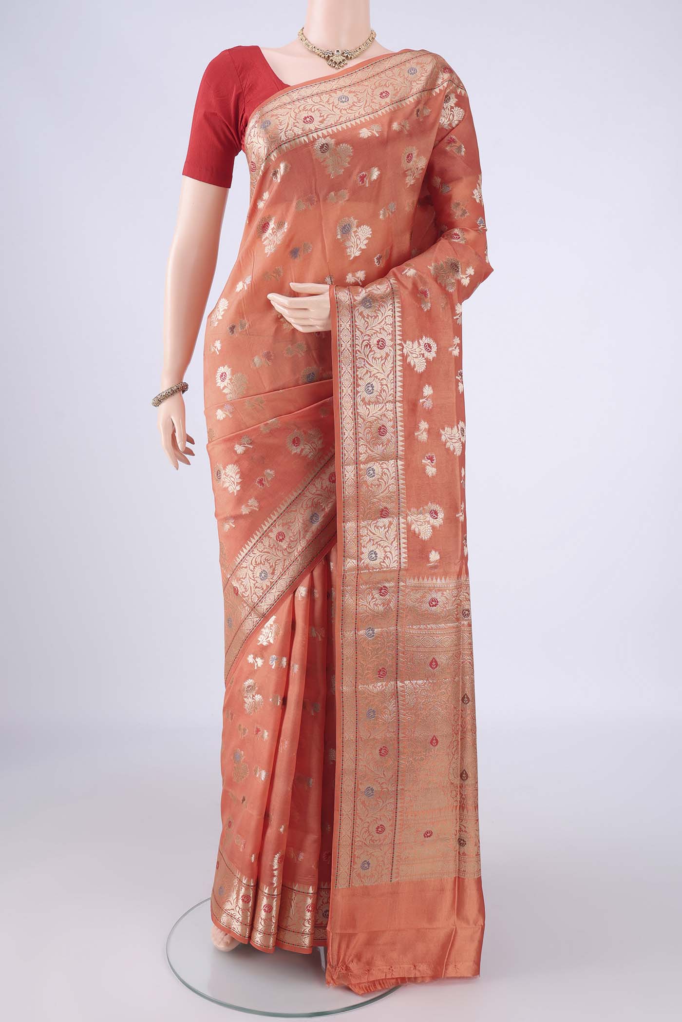 Peach Banarasi Raw Silk Saree with Zari And Thread Butta on the body and Zari Border.  displayed on a mannequin