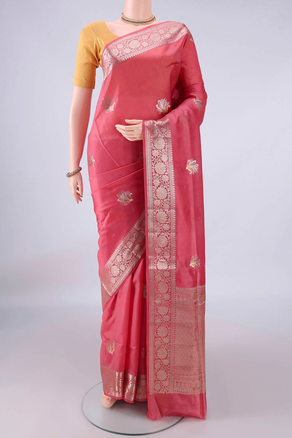 Pure Silk Coral Banarasi Raw Saree with Zari Butta on the body and Zari And Thread Border.  displayed on a mannequin