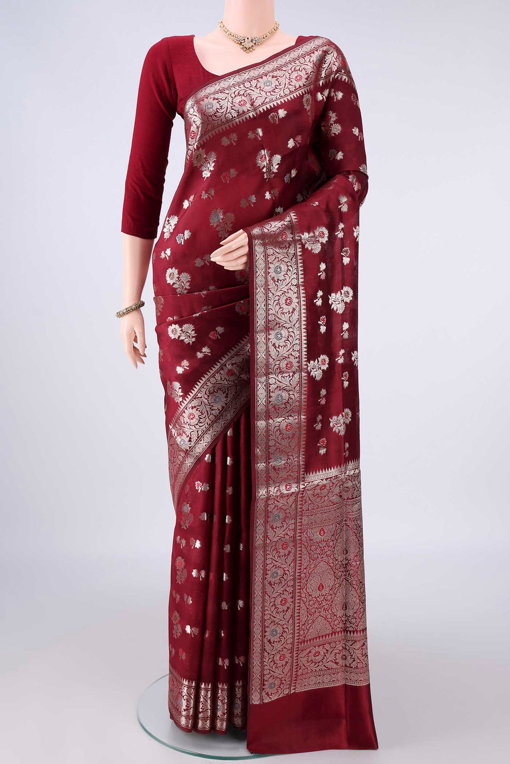 Pure Silk Maroon Banarasi Raw Saree with Zari Butta on the body and Zari Border.  displayed on a mannequin