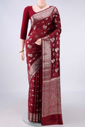 Pure Silk Maroon Banarasi Raw Saree with Zari Butta on the body and Zari Border.  displayed on a mannequin