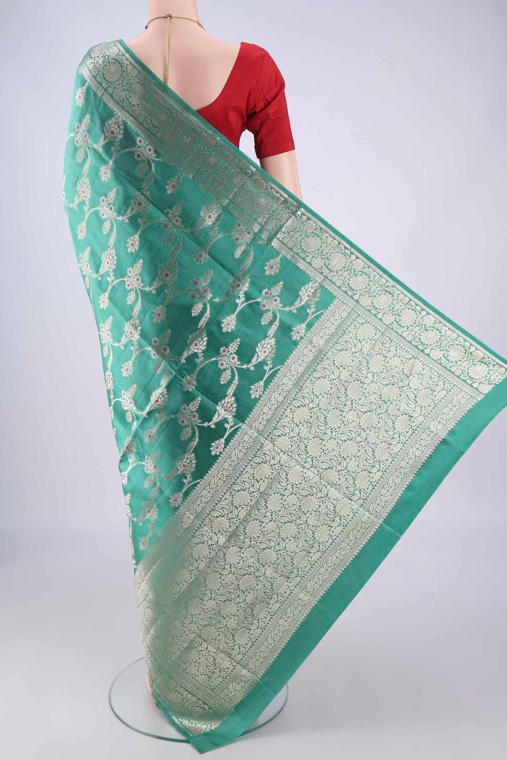 Flat view of Turquoise Banarasi Tussar Silk Saree with Zari And Thread Butta on the body and Zari Border. 