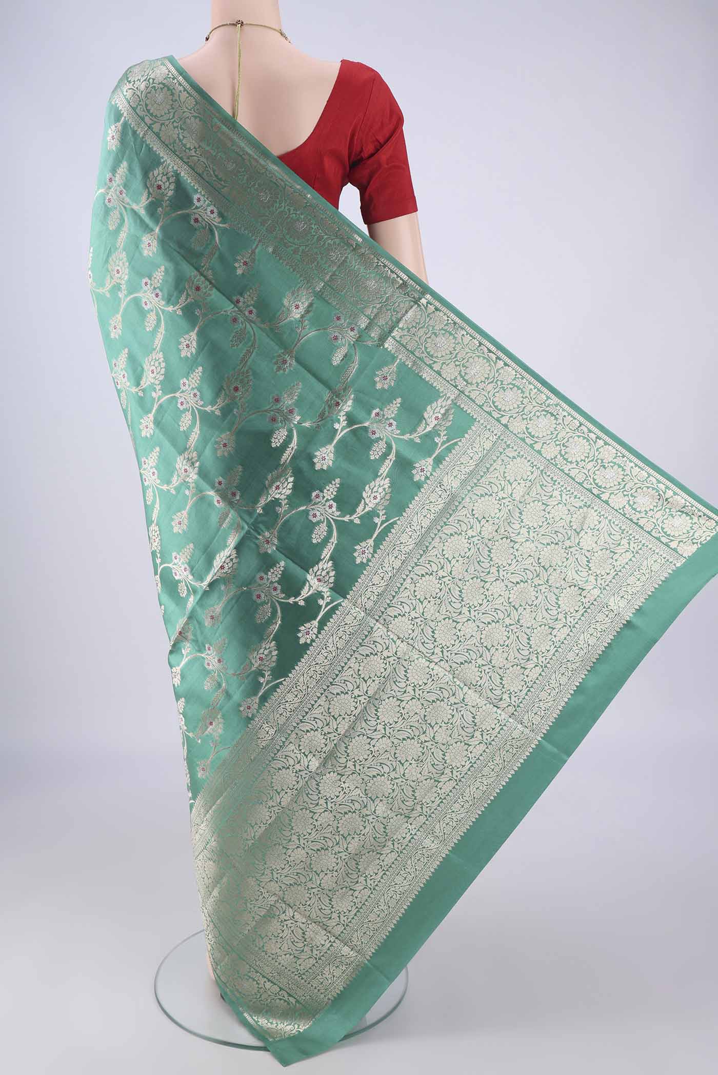 Flat view of Turquoise Banarasi Tussar Silk Saree with Zari And Thread Butta on the body and Zari Border. 