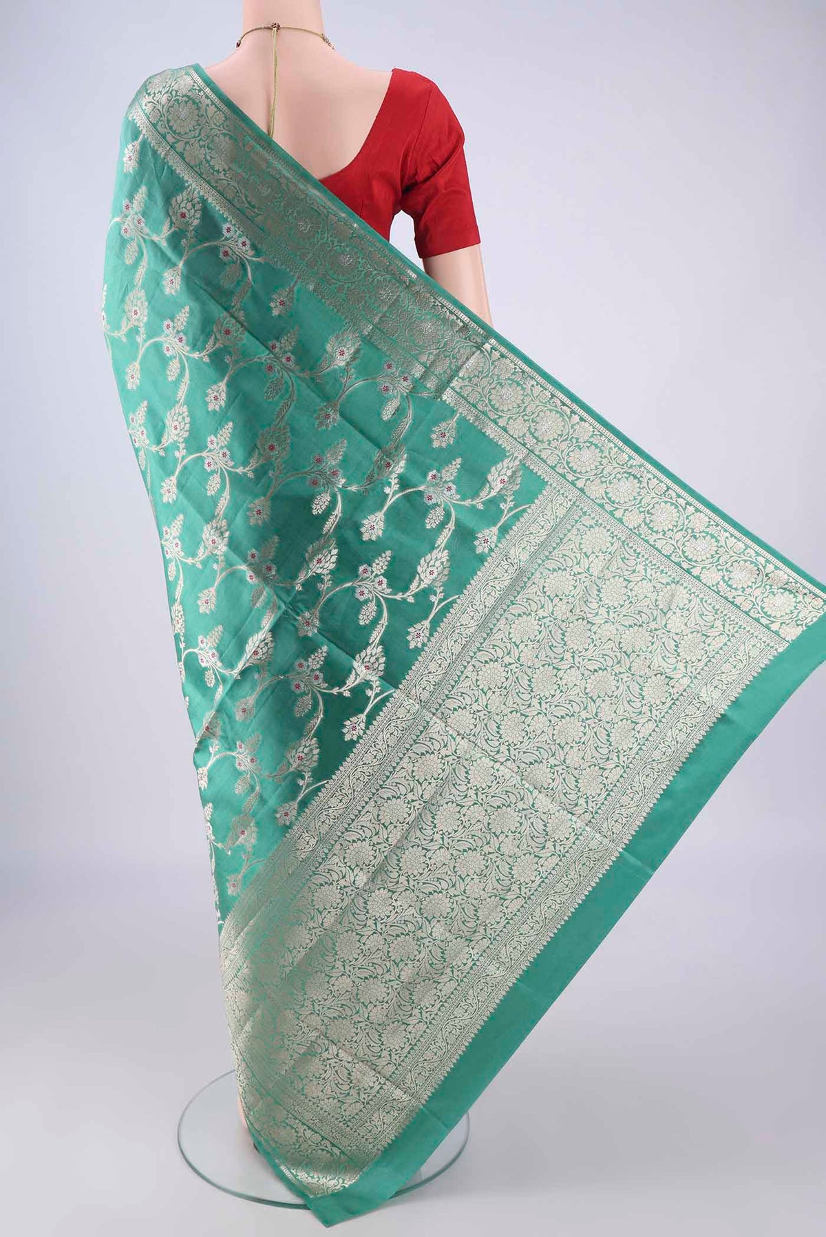 Flat view of Turquoise Banarasi Tussar Silk Saree with Zari And Thread Butta on the body and Zari Border. 