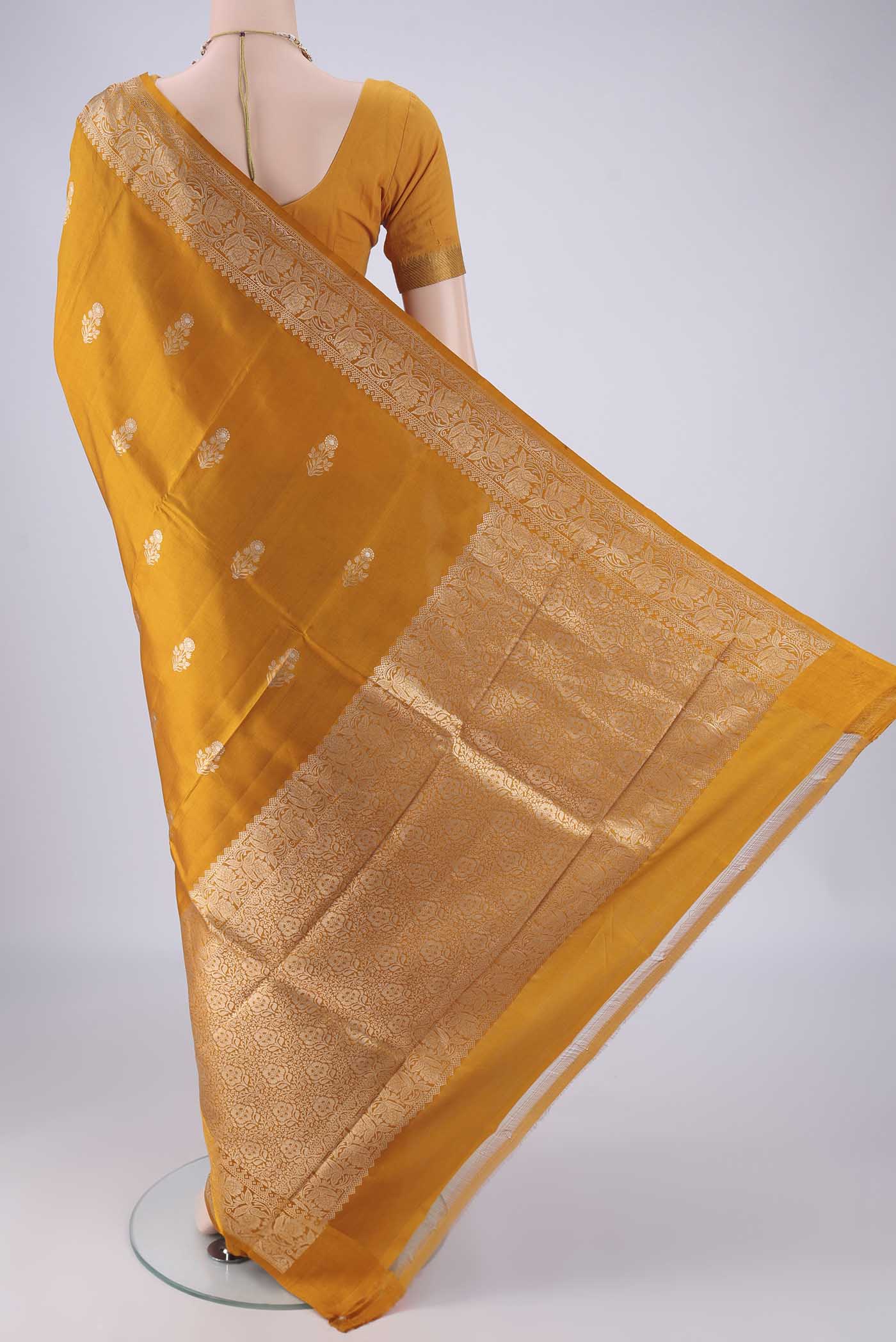 Flat view of Mustard Banarasi Katan Silk Saree with Zari Butta on the body and Zari Border. 