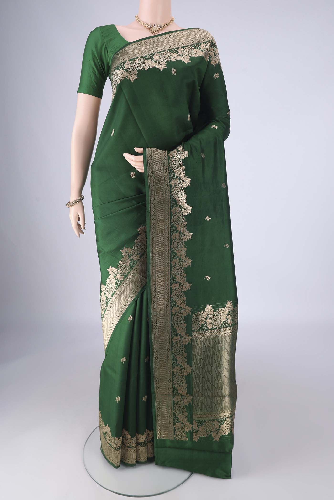 Bottle Green Banarasi Katan Silk Saree with Zari Butta on the body and Zari Border.  displayed on a mannequin