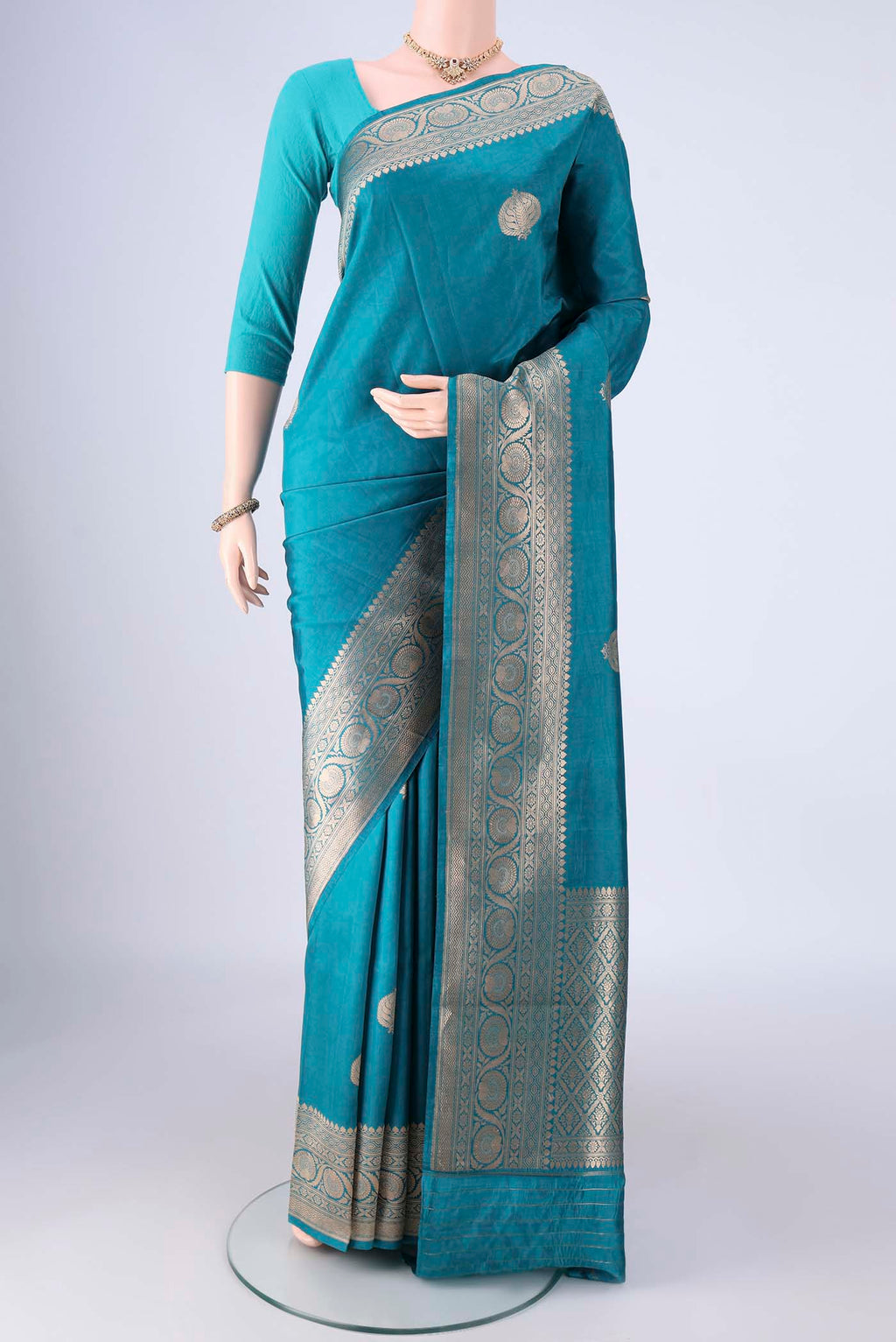 Blue Banarasi Katan Silk Saree with Zari Butta on the body and Zari Border.  displayed on a mannequin