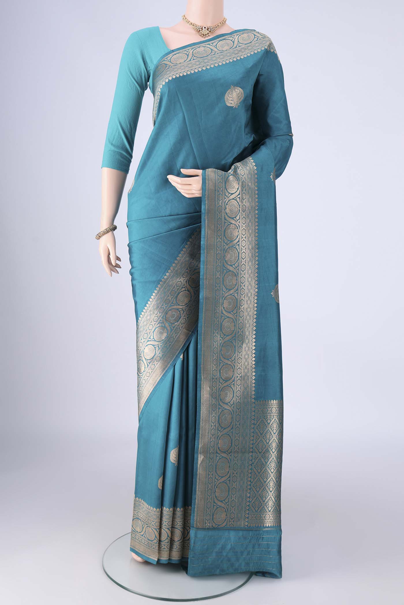 Blue Banarasi Katan Silk Saree with Zari Butta on the body and Zari Border.  displayed on a mannequin