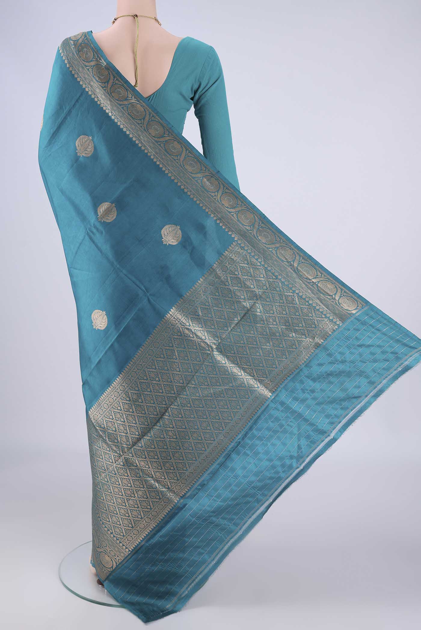 Flat view of Blue Banarasi Katan Silk Saree with Zari Butta on the body and Zari Border. 