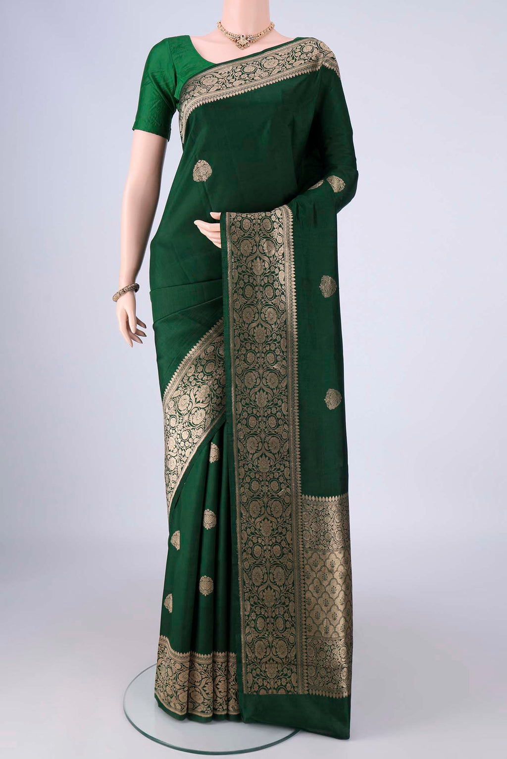 Bottle Green Banarasi Katan Silk Saree with Zari Butta on the body and Zari Border.  displayed on a mannequin