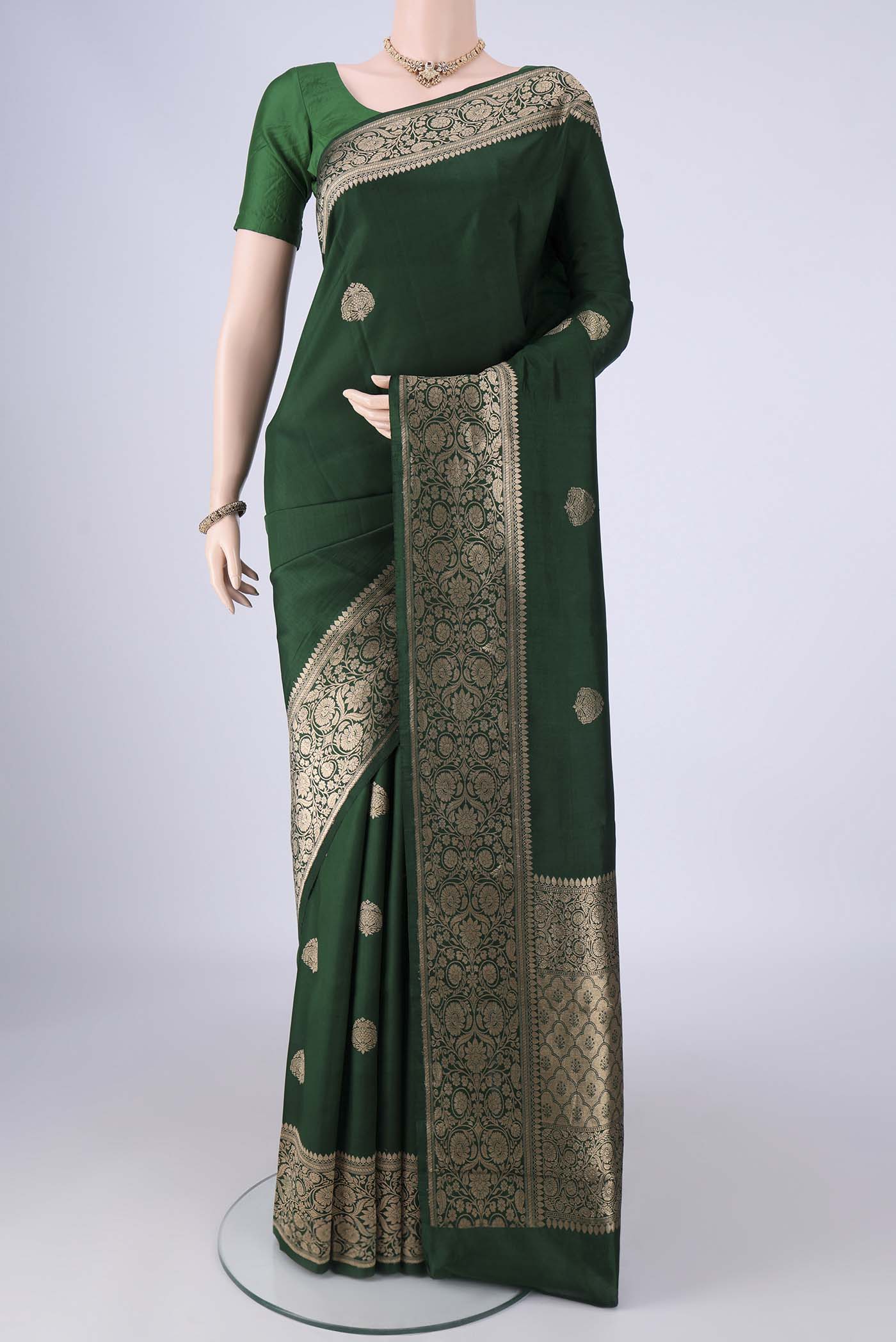 Bottle Green Banarasi Katan Silk Saree with Zari Butta on the body and Zari Border.  displayed on a mannequin