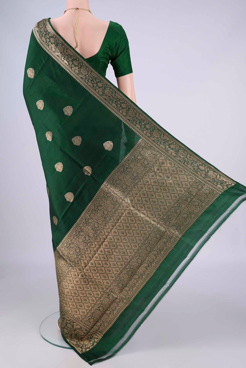 Flat view of Bottle Green Banarasi Katan Silk Saree with Zari Butta on the body and Zari Border. 