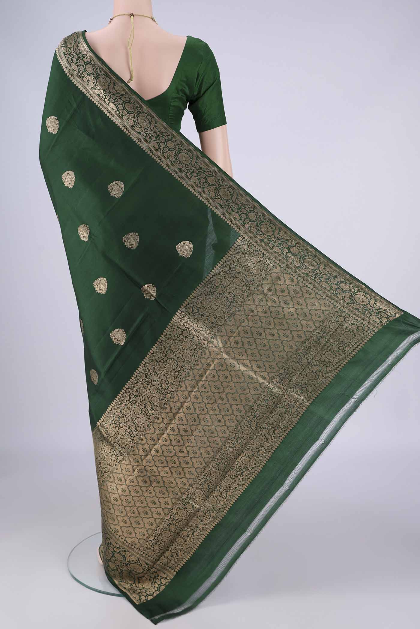 Flat view of Bottle Green Banarasi Katan Silk Saree with Zari Butta on the body and Zari Border. 