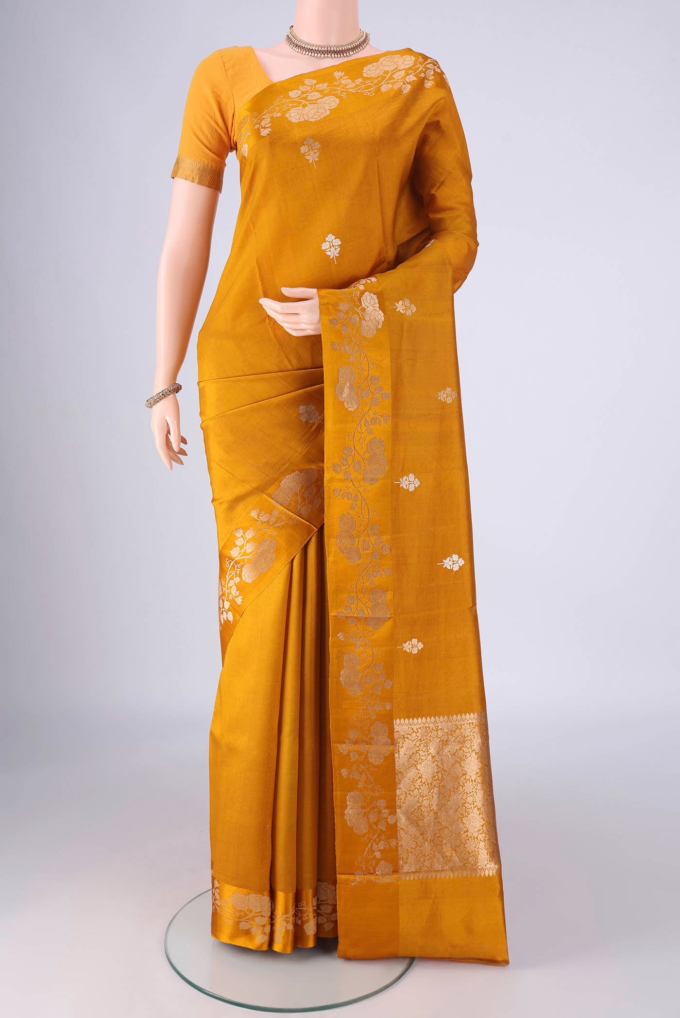 Mustard Banarasi Katan Silk Saree with Zari Butta on the body and Zari Border.  displayed on a mannequin