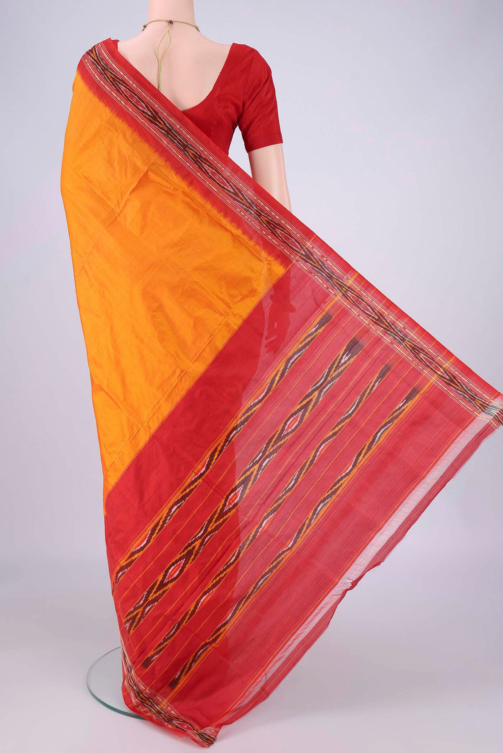 Flat view of Orange Pochampally Silk Saree with Plain Body and Ikat Border. 