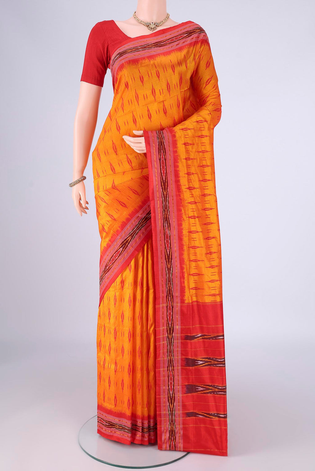 Orange Pochampally Silk Saree with Pure Ikat on the body and Ikat Border.  displayed on a mannequin