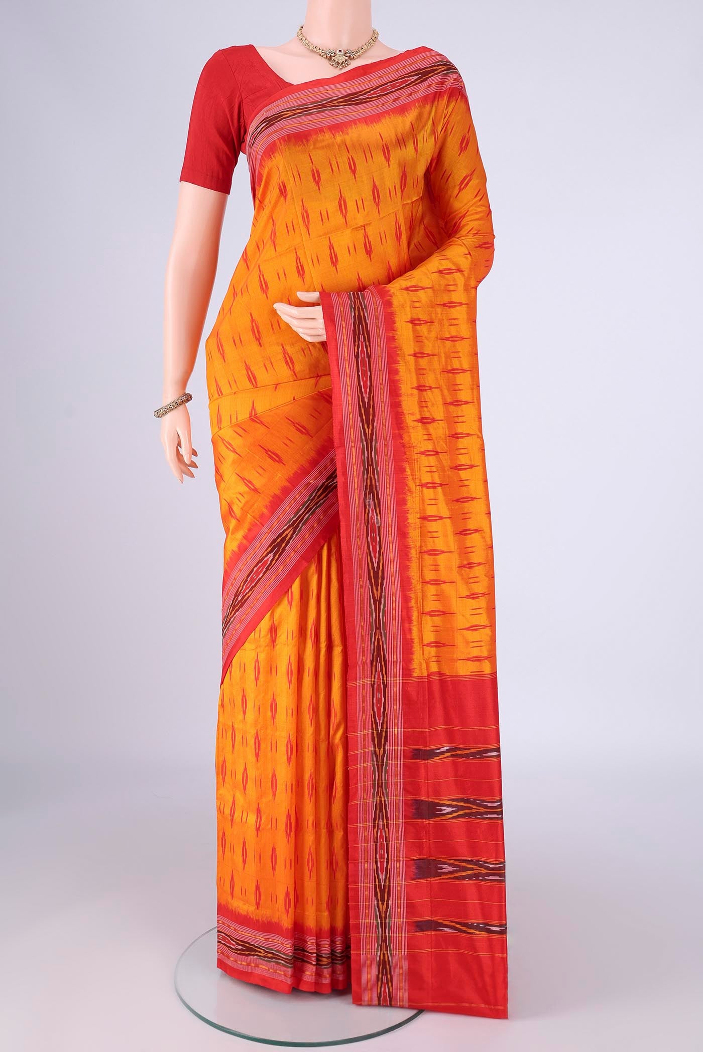 Orange Pochampally Silk Saree with Pure Ikat on the body and Ikat Border.  displayed on a mannequin