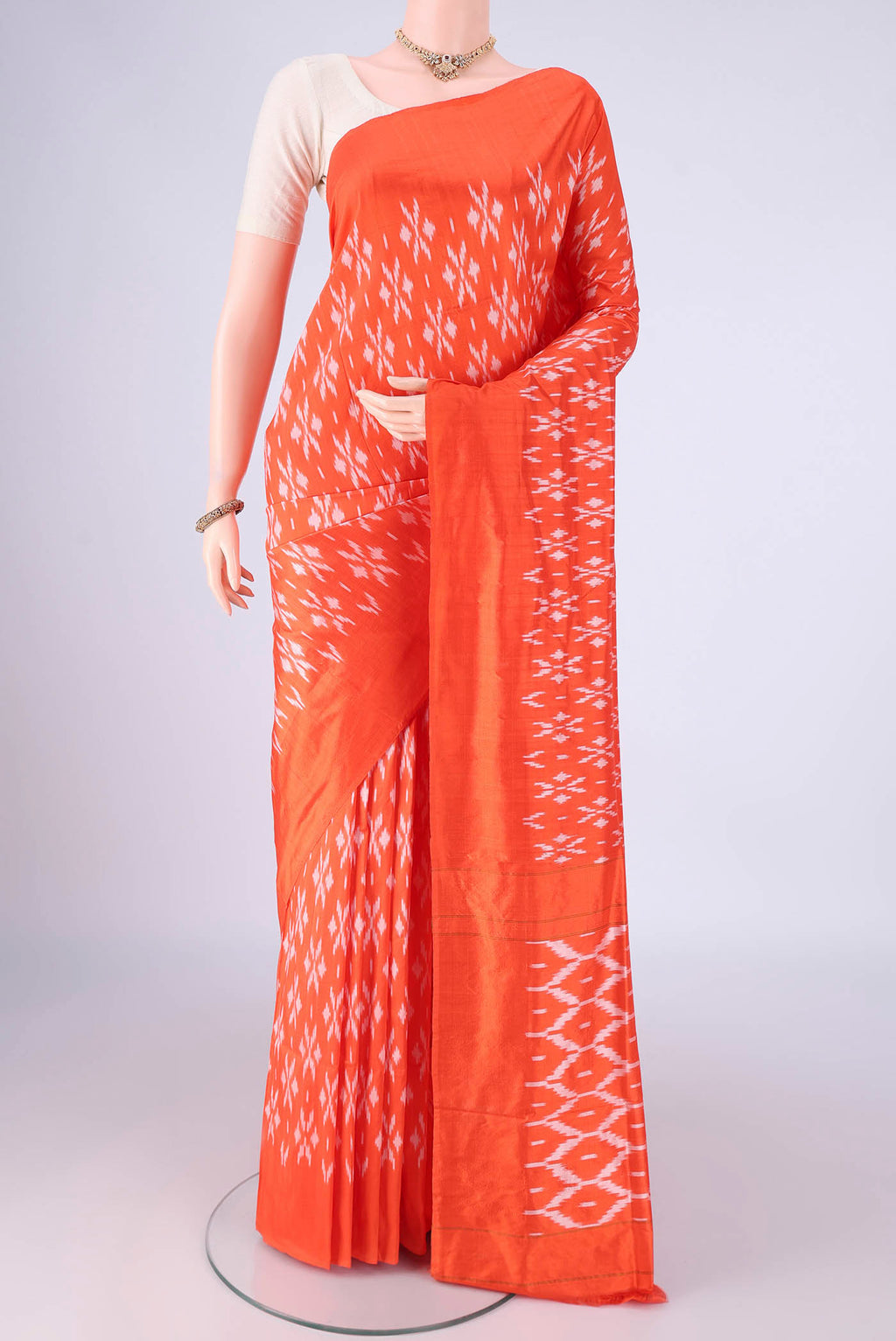Orange Pochampally Silk Saree with Pure Ikat on the body and Without Border.  displayed on a mannequin