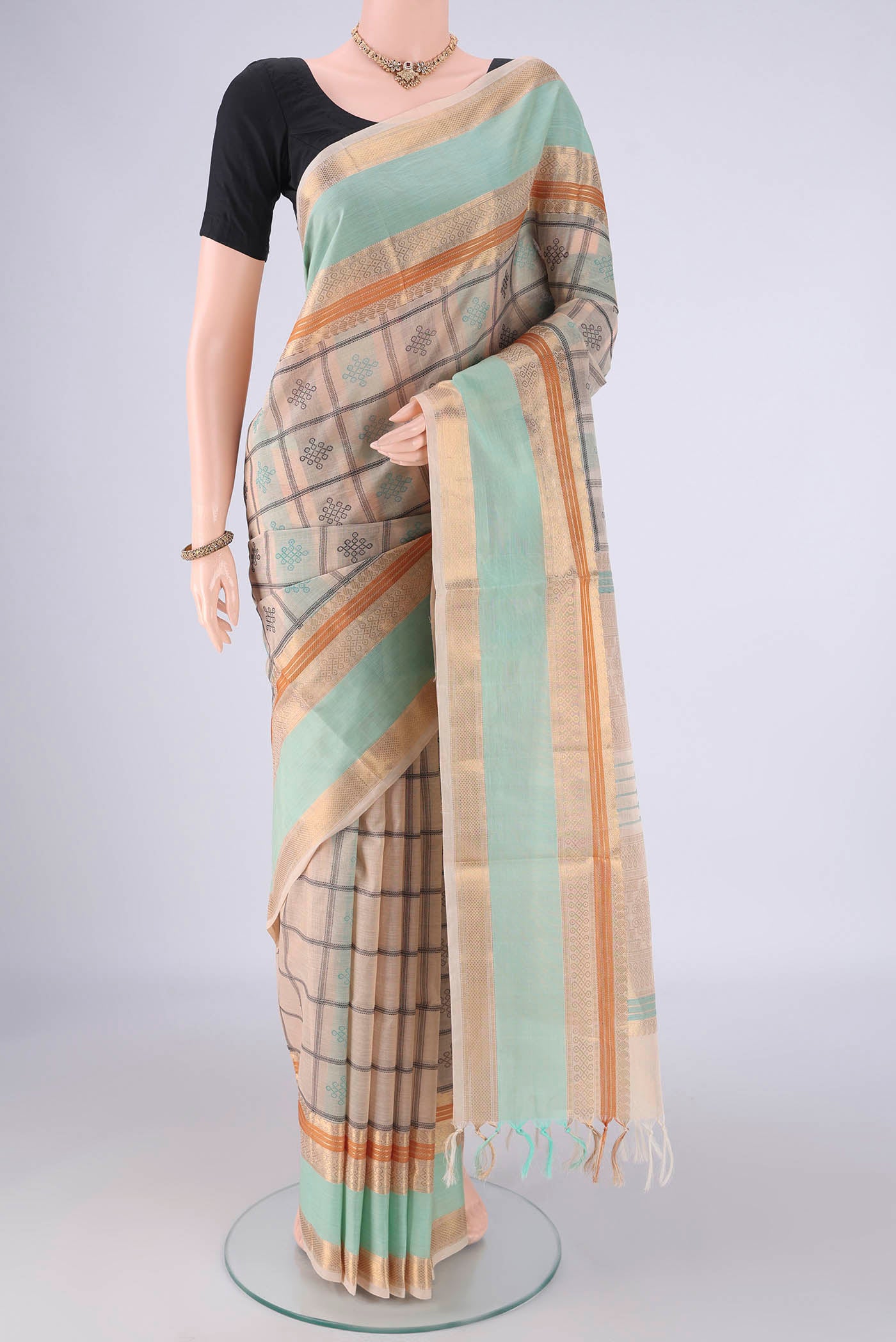Beige Coimbatore Silk Cotton Saree with Checked design on the body and Zari Border.  displayed on a mannequin