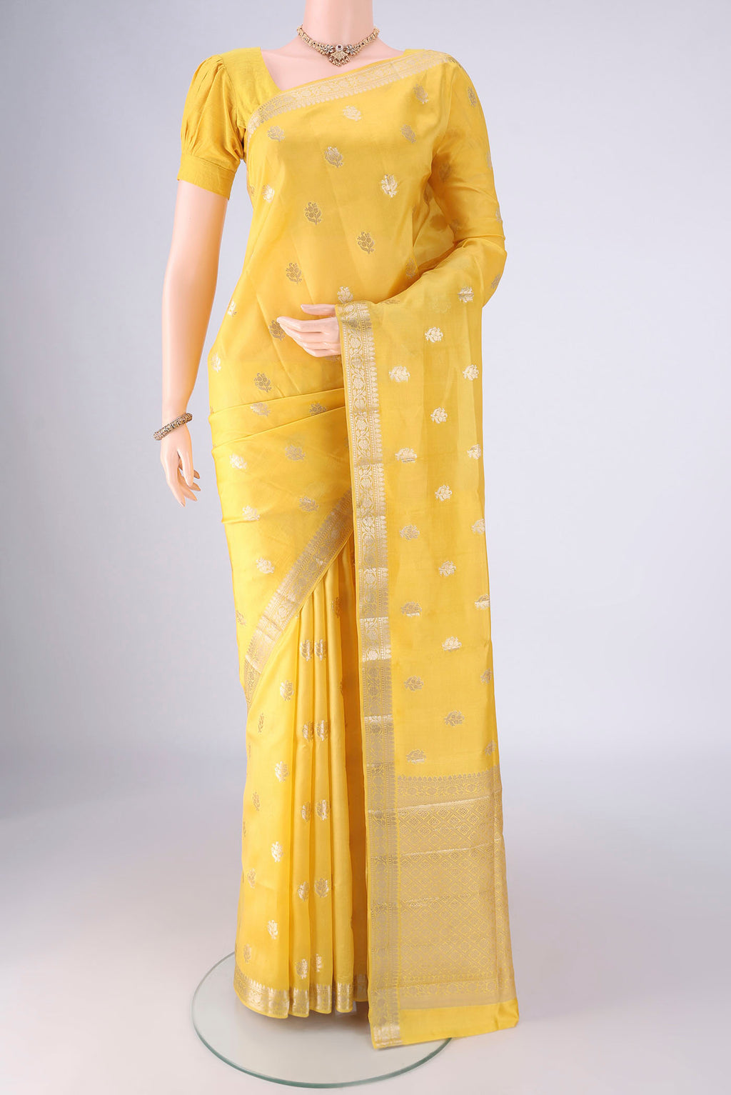 Yellow Banarasi Raw Silk Saree with Zari Butta on the body and Zari Border.  displayed on a mannequin
