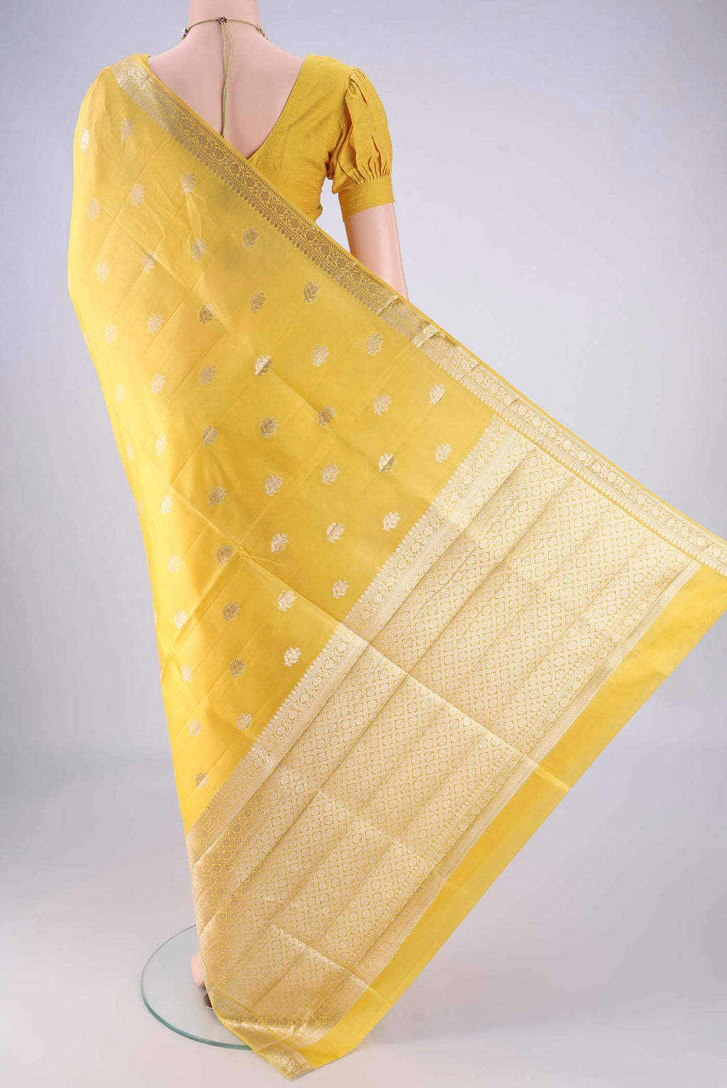 Flat view of Yellow Banarasi Raw Silk Saree with Zari Butta on the body and Zari Border. 