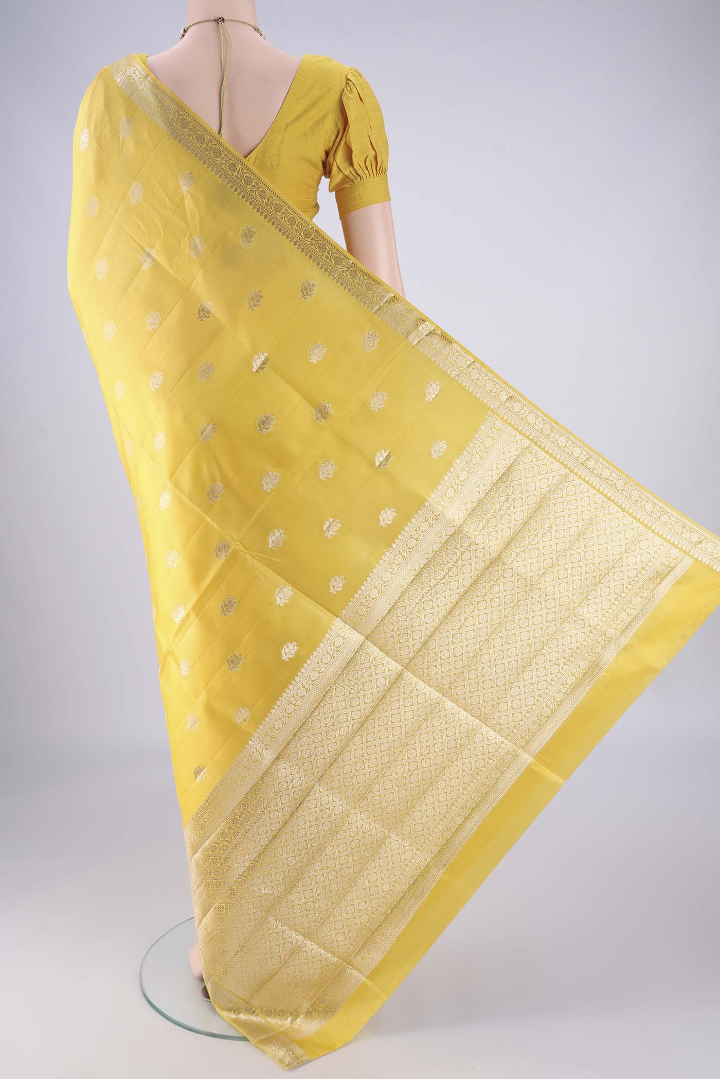 Flat view of Yellow Banarasi Raw Silk Saree with Zari Butta on the body and Zari Border. 