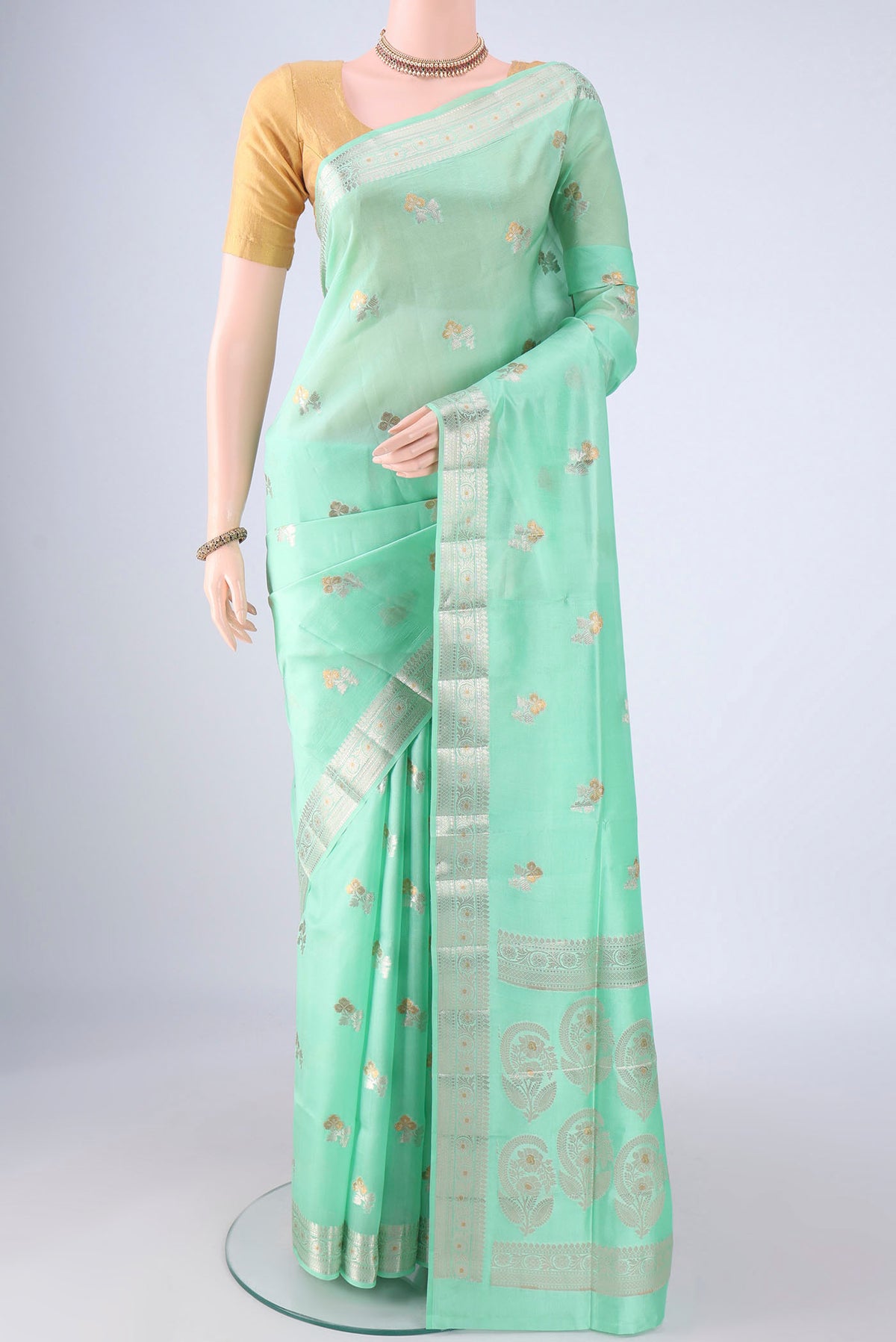 Sea Green Banarasi Tussar Silk Saree with Zari And Thread Butta on the body and Zari Border.  displayed on a mannequin