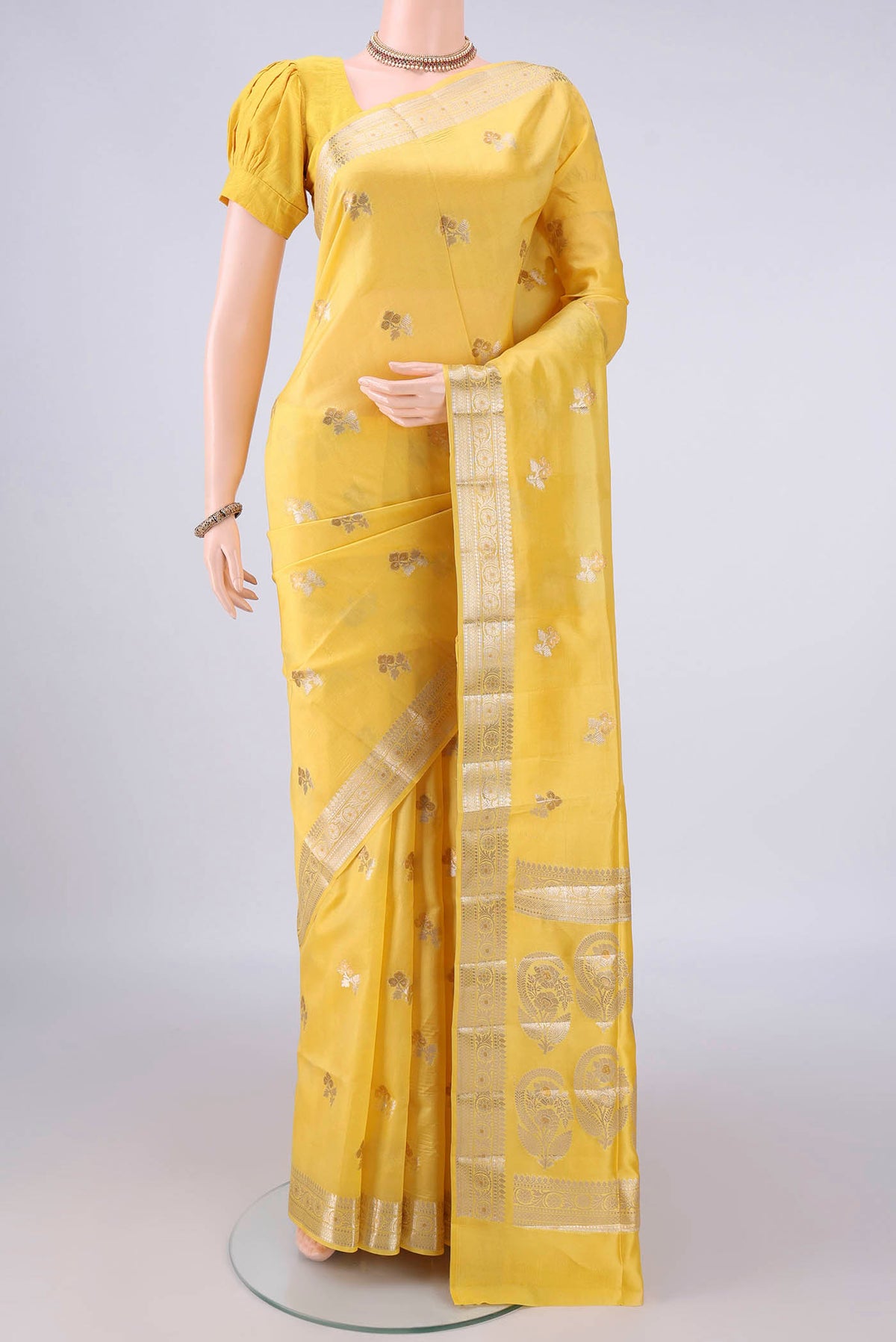 Pure Silk Yellow Banarasi Raw Saree with Zari Butta on the body and Zari Border.  displayed on a mannequin