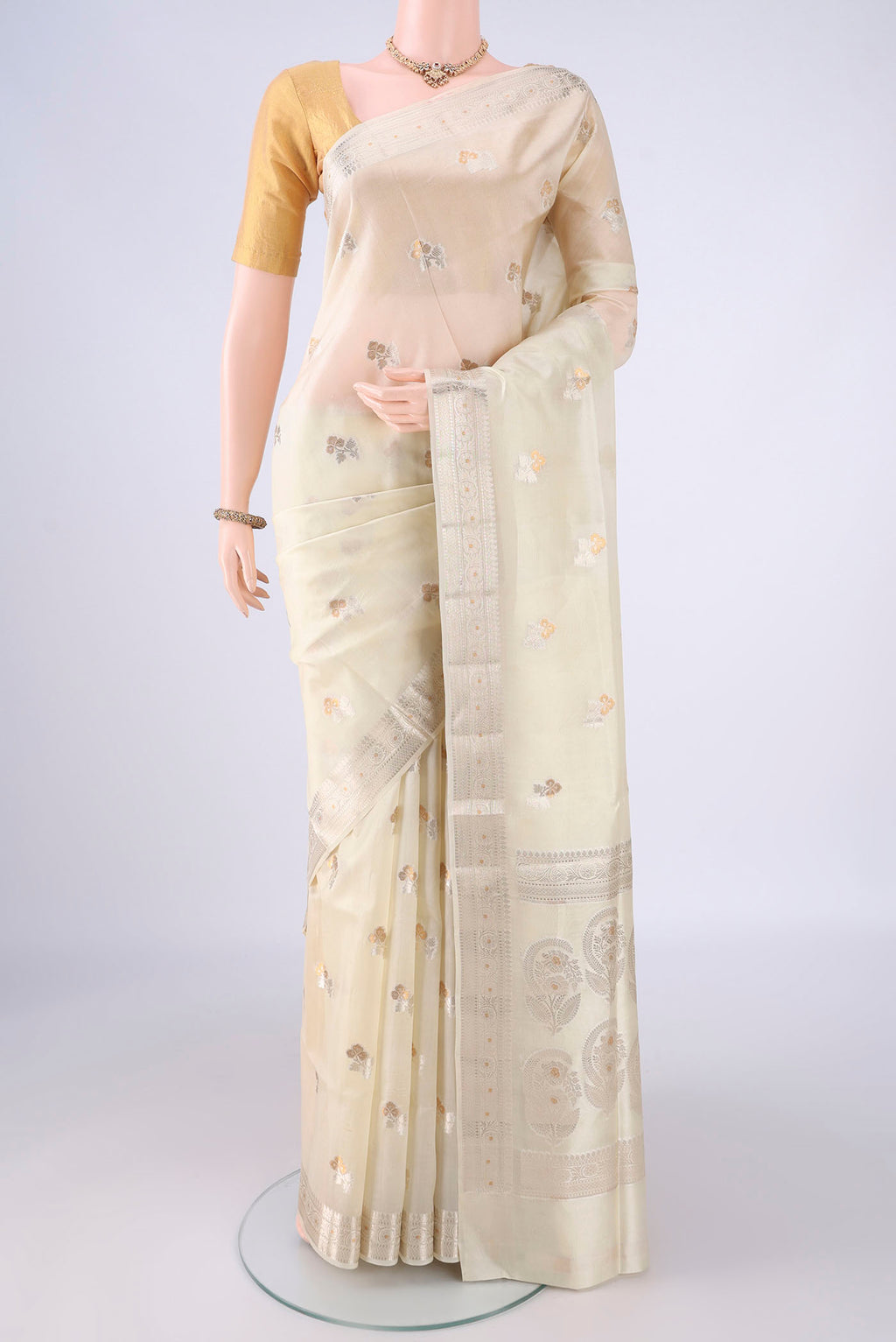 Cream Banarasi Raw Silk Saree with Zari Butta on the body and Zari Border.  displayed on a mannequin