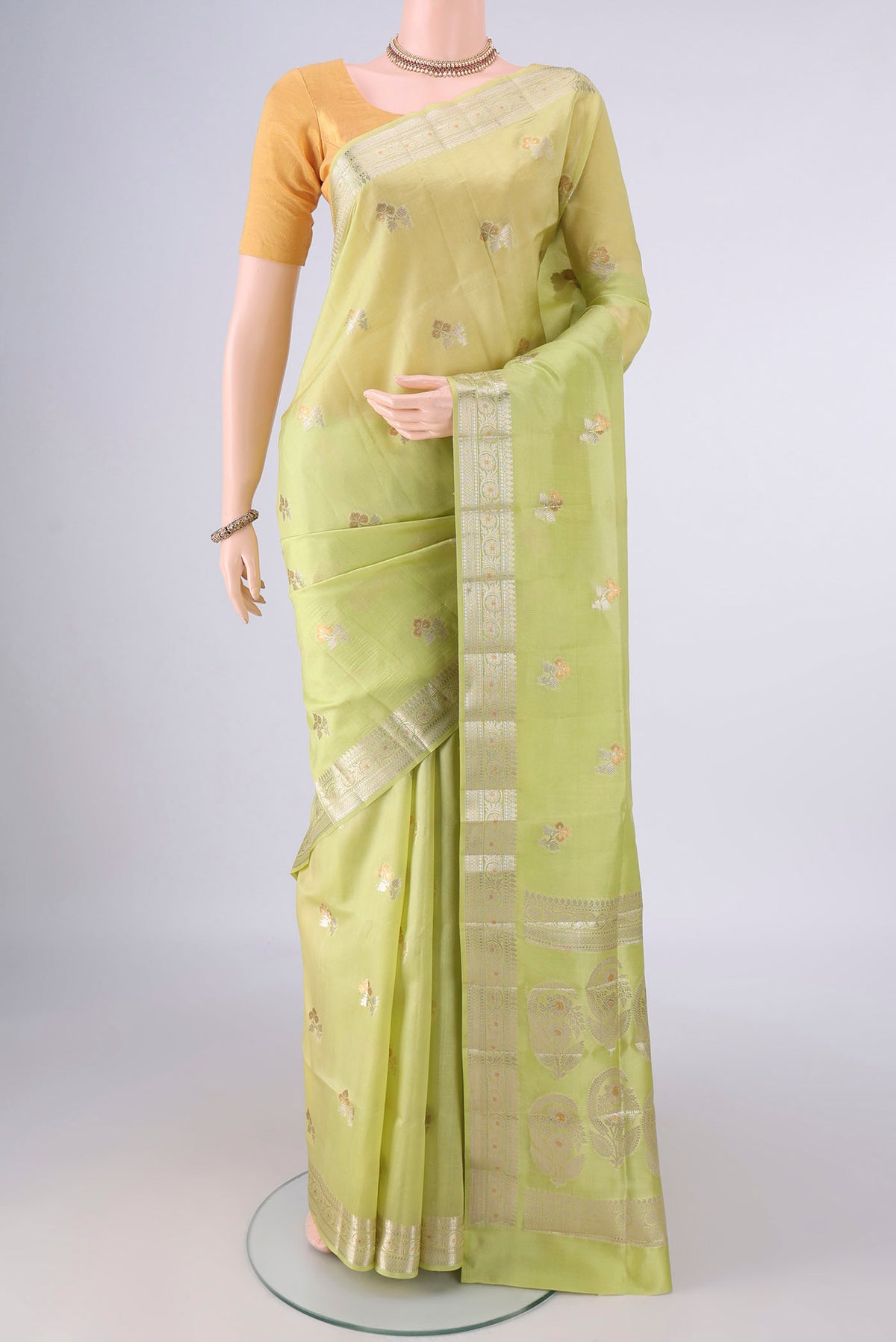 Pure Silk Acid Green Banarasi Raw Saree with Zari And Thread Butta on the body and Zari Border.  displayed on a mannequin