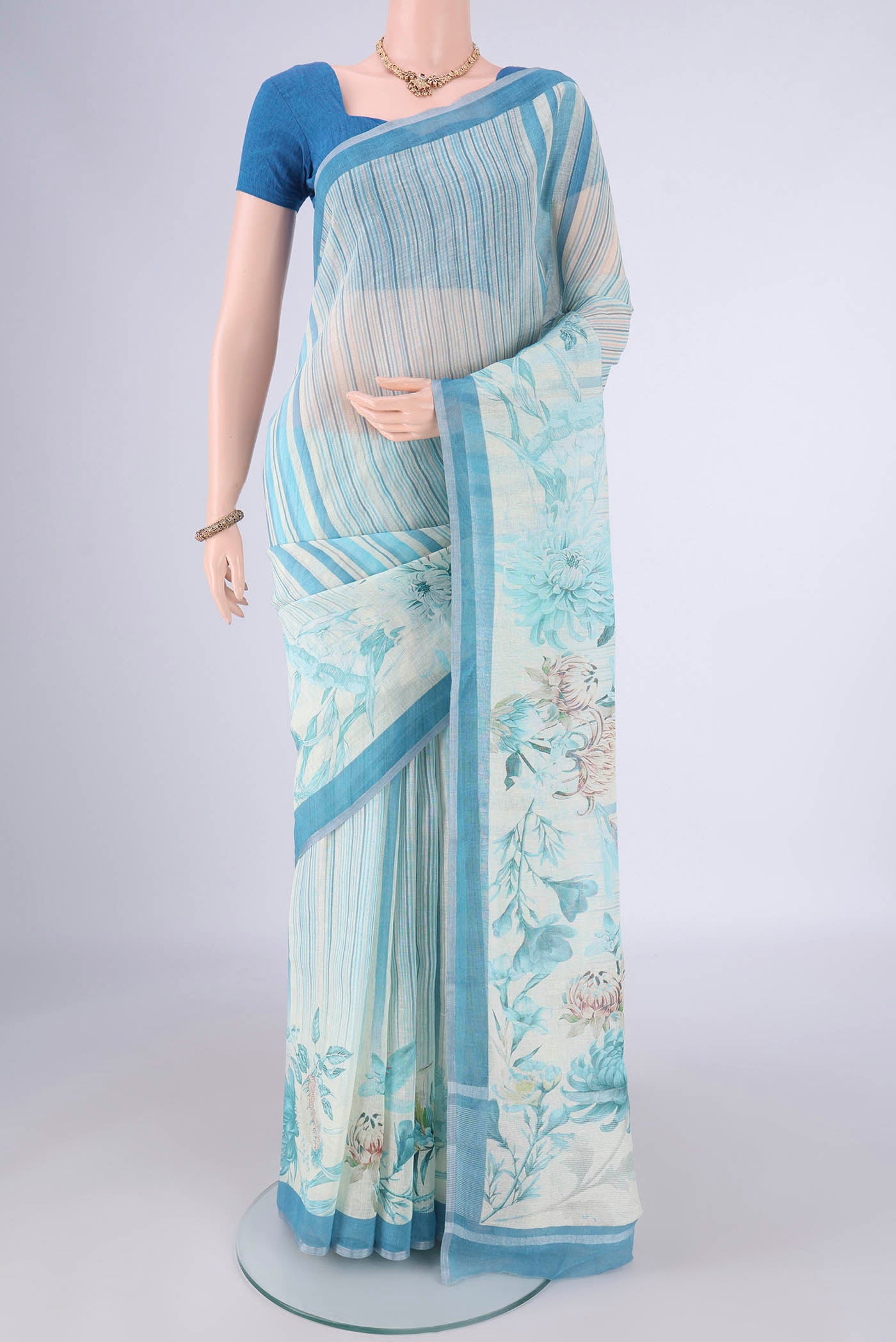 Off White Linen Saree with Geometric Print on the body and Zari Border.  displayed on a mannequin