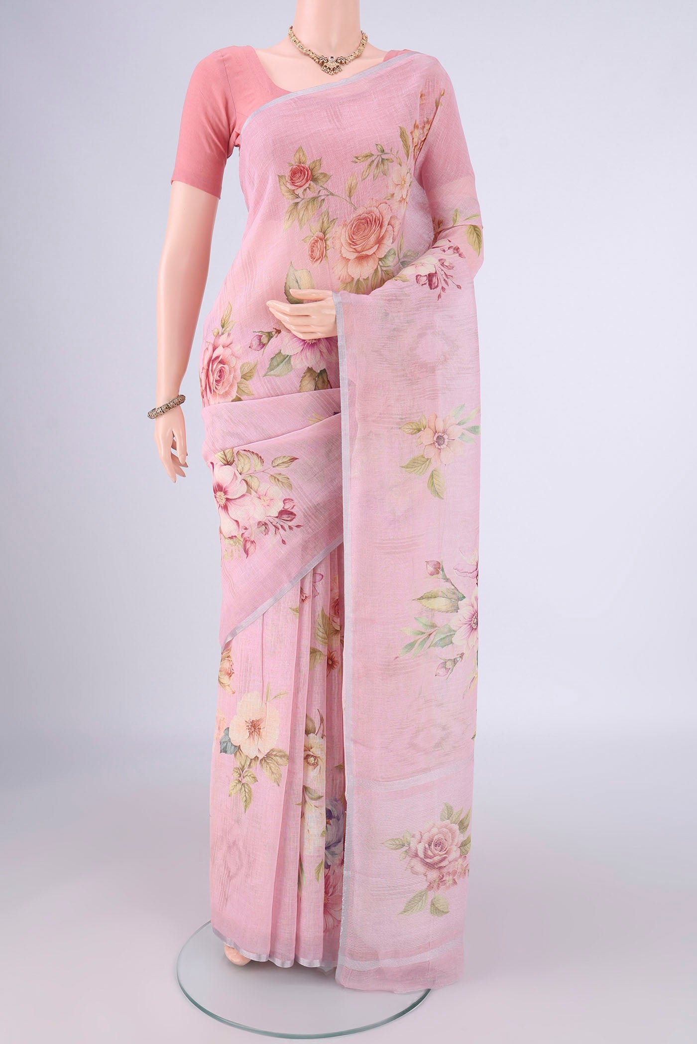 Rani Pink Linen Saree with Floral Print on the body and Zari Border.  displayed on a mannequin