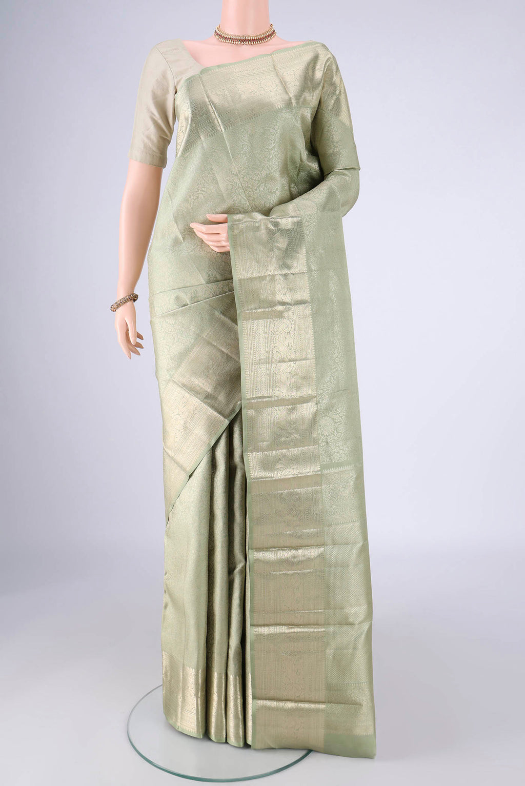 Sage Green Kanchipuram Silk Saree with Zari Brocade on the body and Zari Border.  displayed on a mannequin
